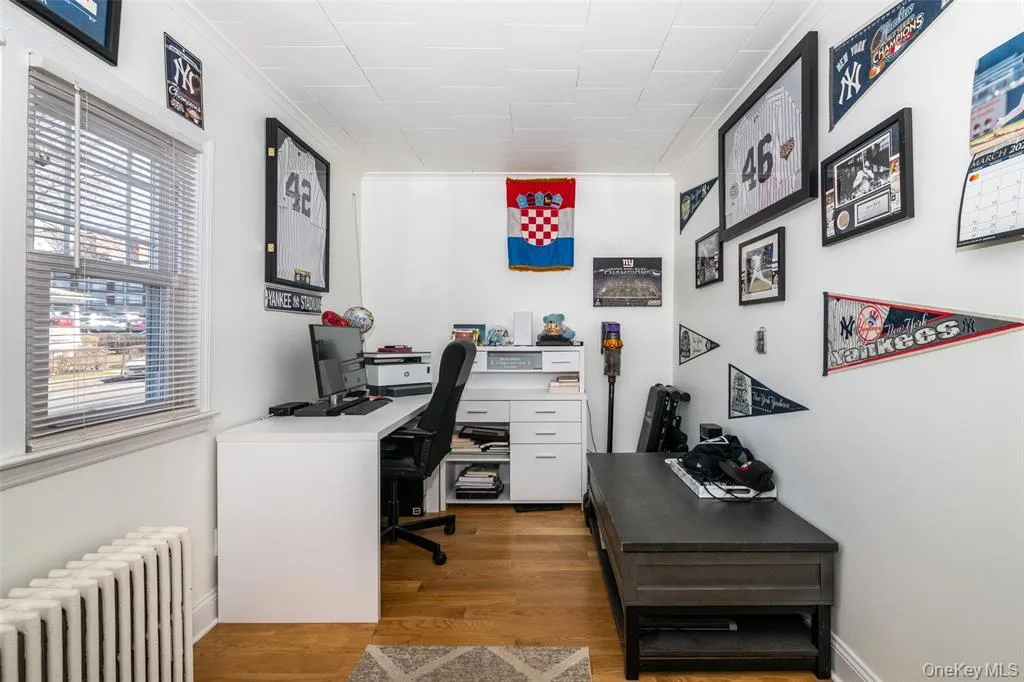 Office featuring radiator, light wood-style flooring, and ornamental molding Office featuring radiator, light wood-style flooring, and ornamental molding