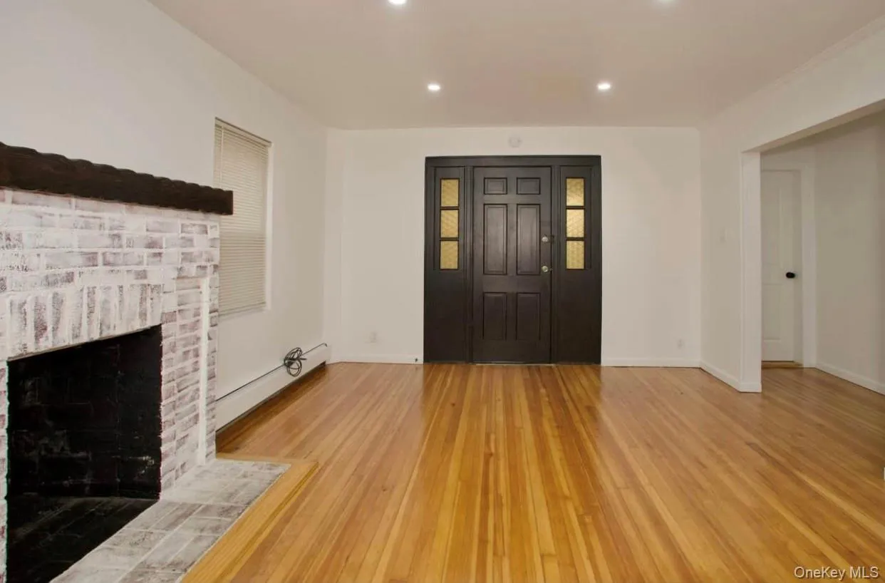 Unfurnished living room featuring light wood-style floors, a fireplace, a baseboard heating unit, and recessed lighting Unfurnished living room featuring light wood-style floors, a fireplace, a baseboard heating unit, and recessed lighting