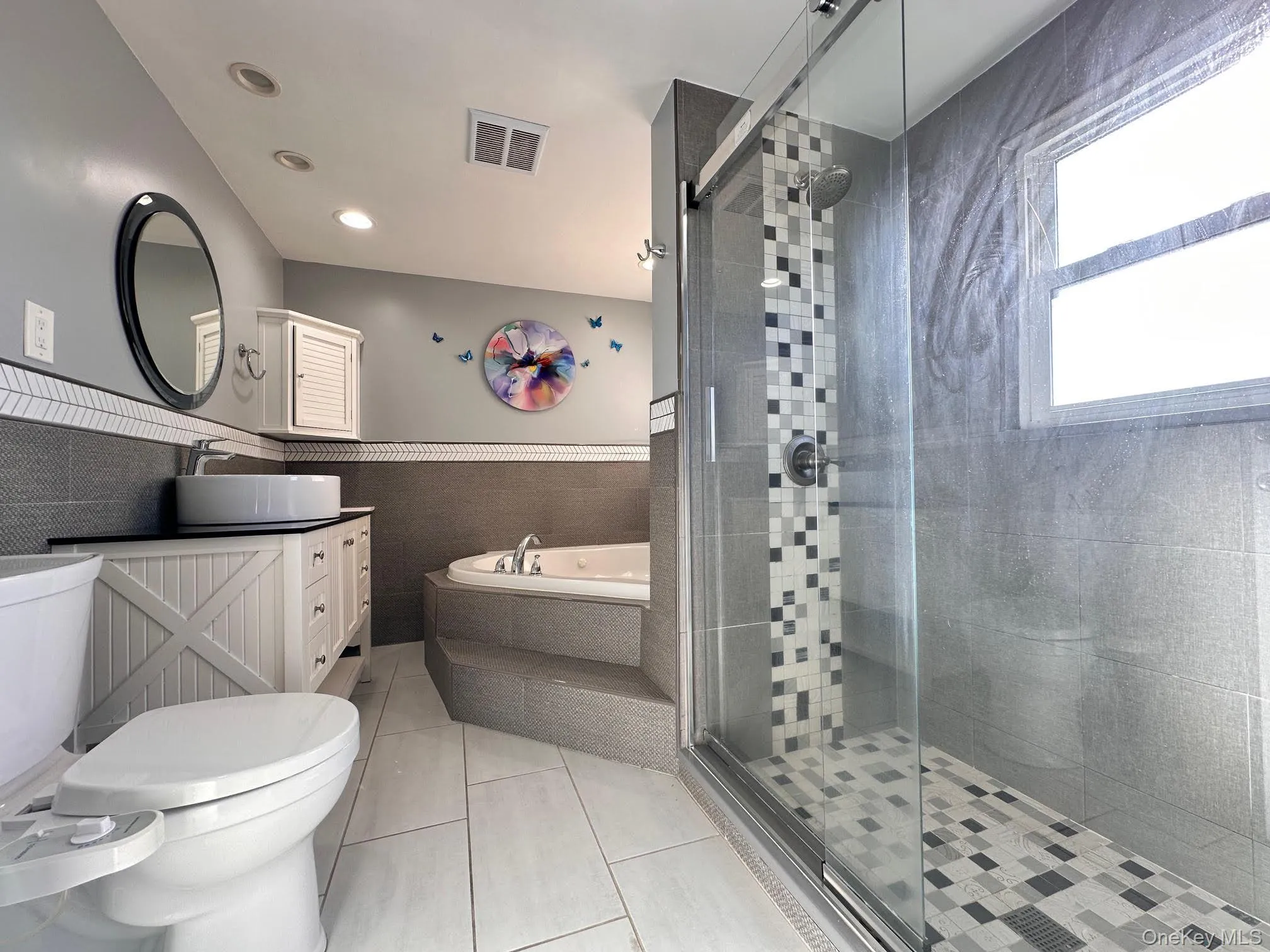 Bathroom featuring a bath, wainscoting, vanity, light tile patterned floors, and a shower stall Bathroom featuring a bath, wainscoting, vanity, light tile patterned floors, and a shower stall