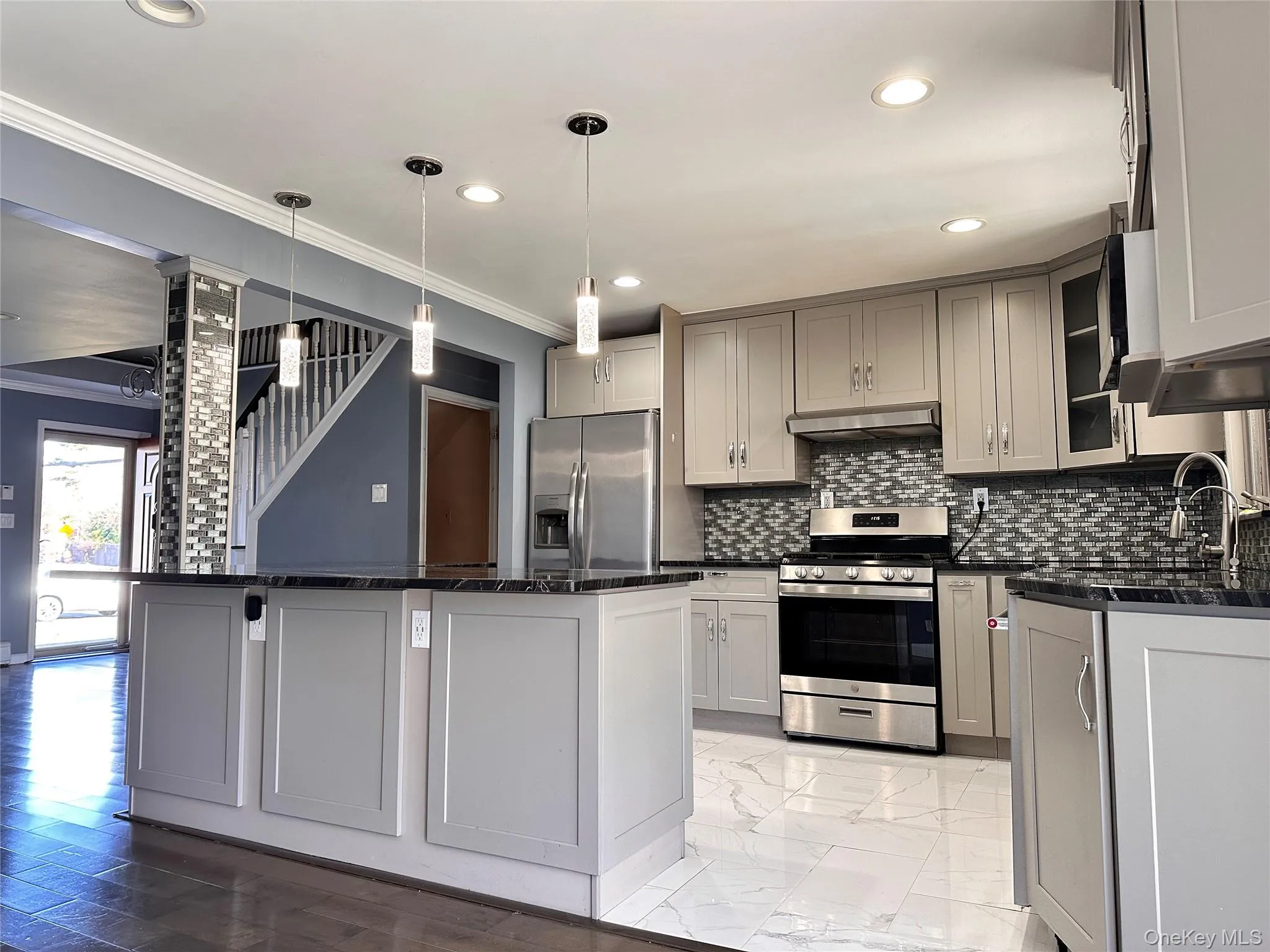 Kitchen featuring appliances with stainless steel finishes, ornamental molding, pendant lighting, gray cabinetry, and recessed lighting Kitchen featuring appliances with stainless steel finishes, ornamental molding, pendant lighting, gray cabinetry, and recessed lighting