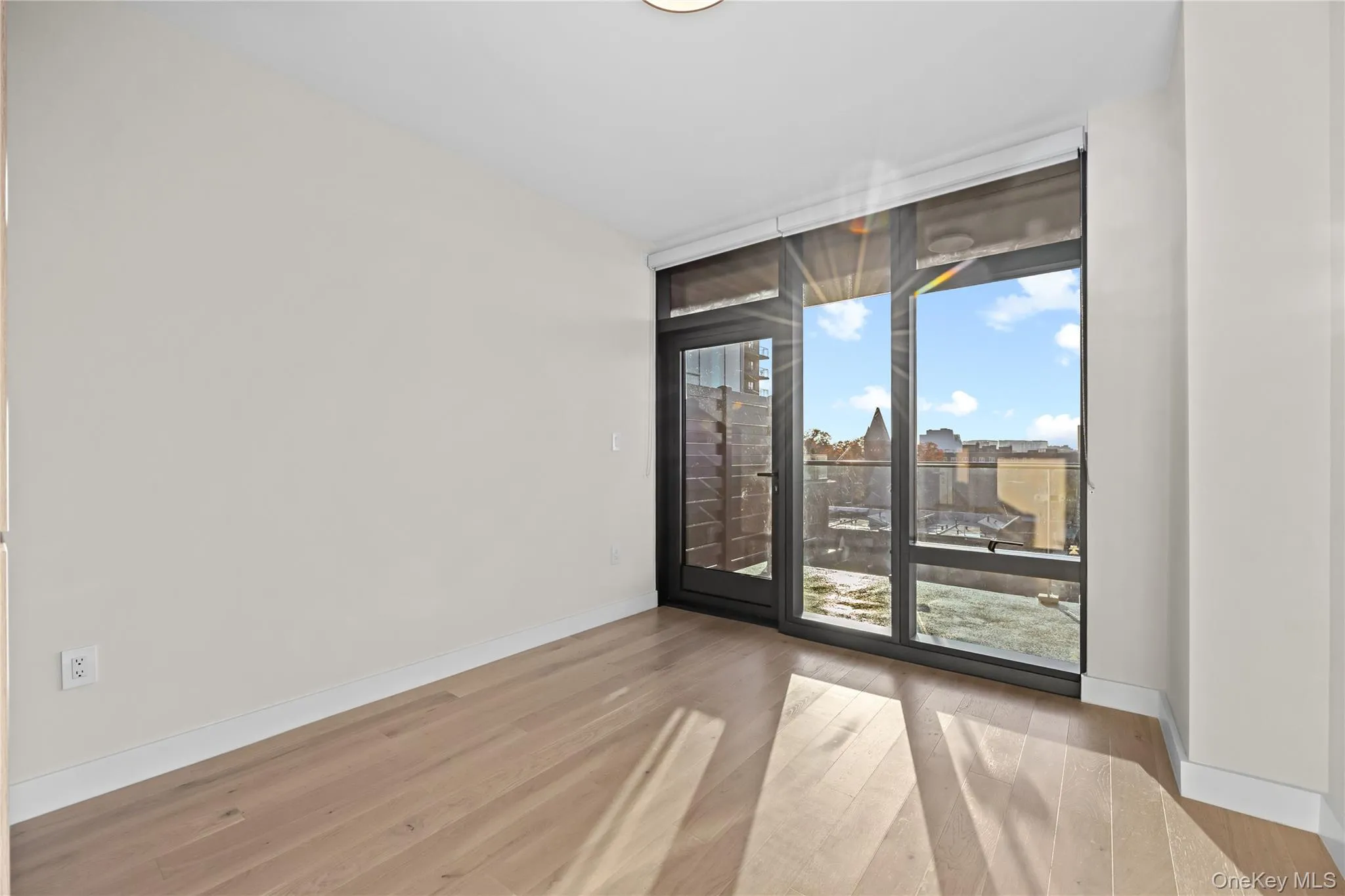 Unfurnished room featuring light wood-type flooring and floor to ceiling windows Unfurnished room featuring light wood-type flooring and floor to ceiling windows