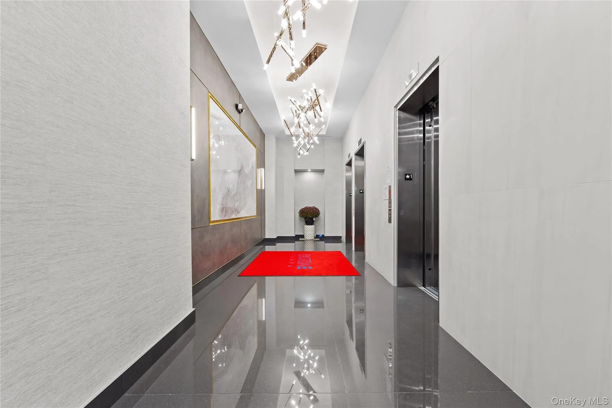 Hall with granite floors, elevator, and a chandelier Hall with granite floors, elevator, and a chandelier