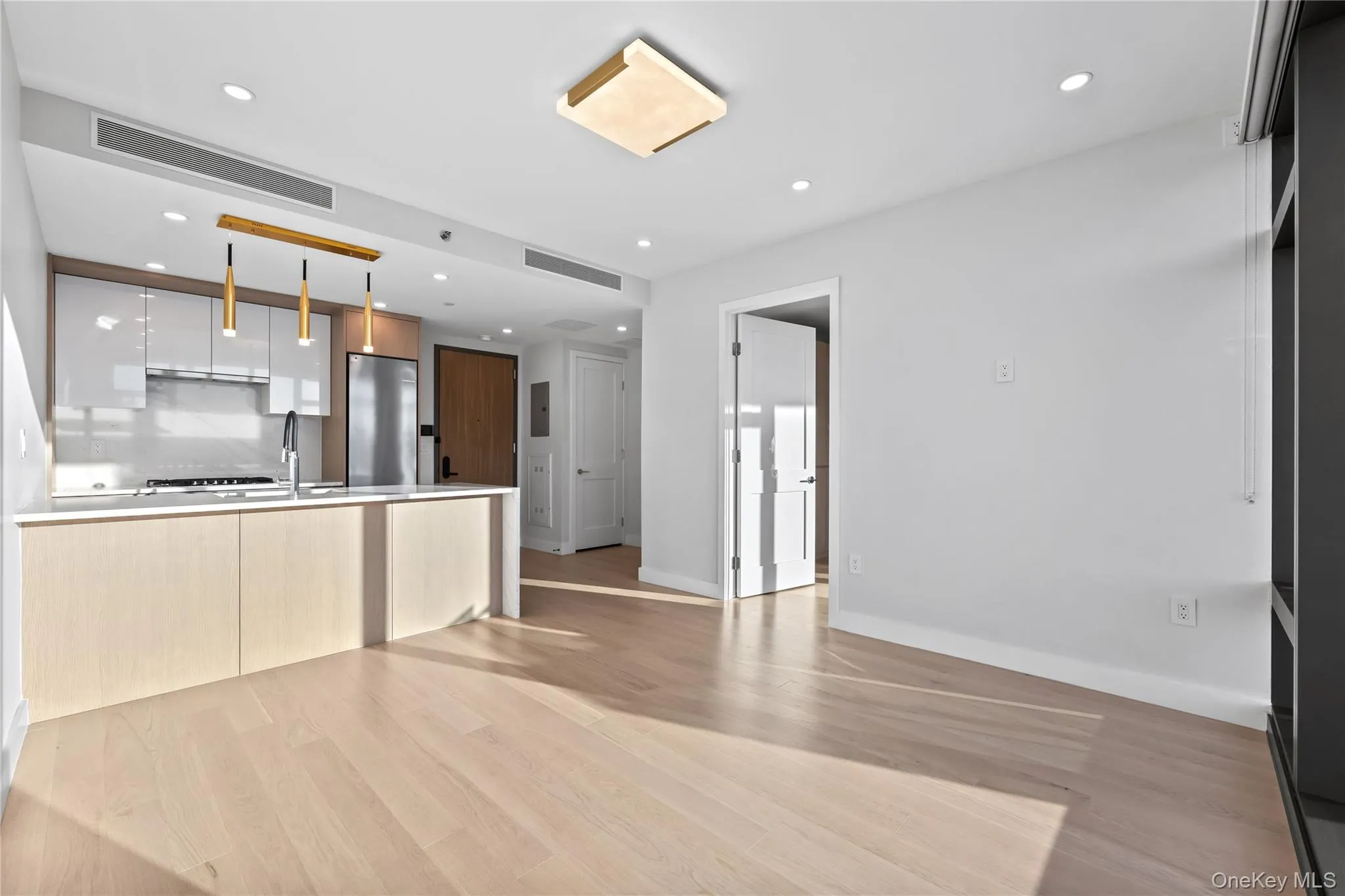 Unfurnished living room featuring light wood-style flooring and recessed lighting Unfurnished living room featuring light wood-style flooring and recessed lighting