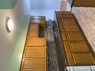 Kitchen featuring backsplash, range, brown cabinets, dark stone counters, and light wood-type flooring Kitchen featuring backsplash, range, brown cabinets, dark stone counters, and light wood-type flooring