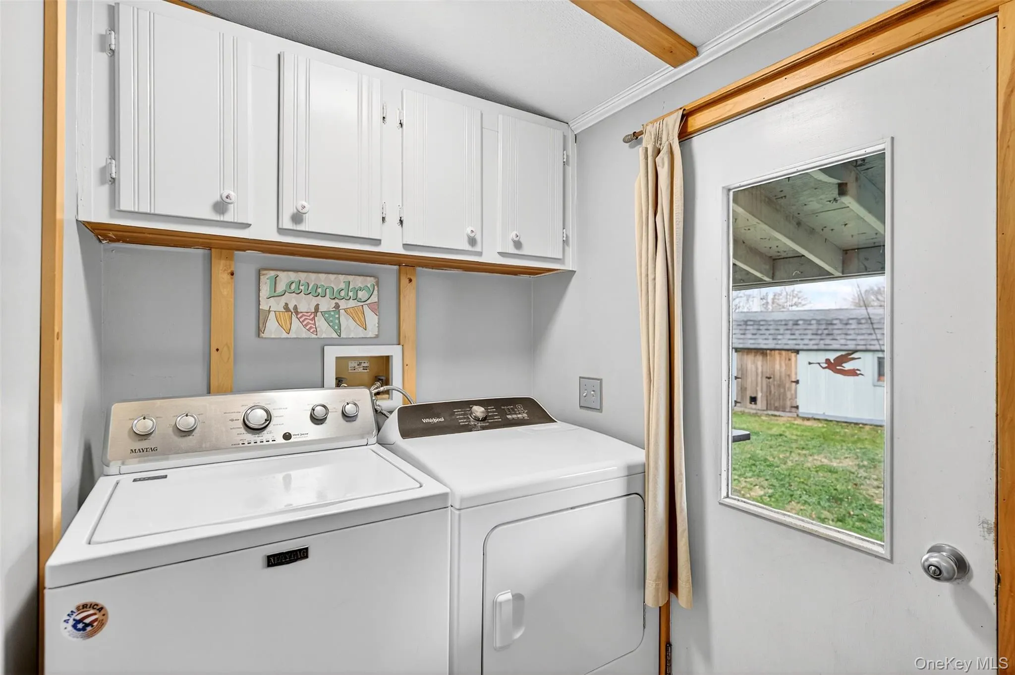 Laundry area with washer and clothes dryer, cabinet space, and ornamental molding Laundry area with washer and clothes dryer, cabinet space, and ornamental molding