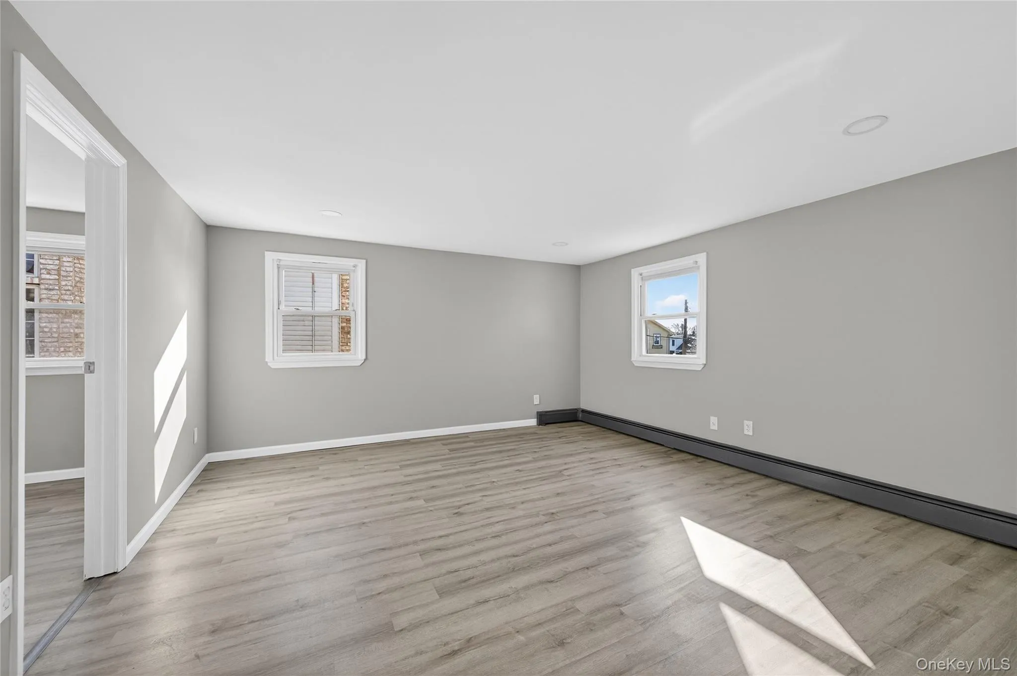 Spare room featuring light wood-style flooring and a baseboard radiator Spare room featuring light wood-style flooring and a baseboard radiator