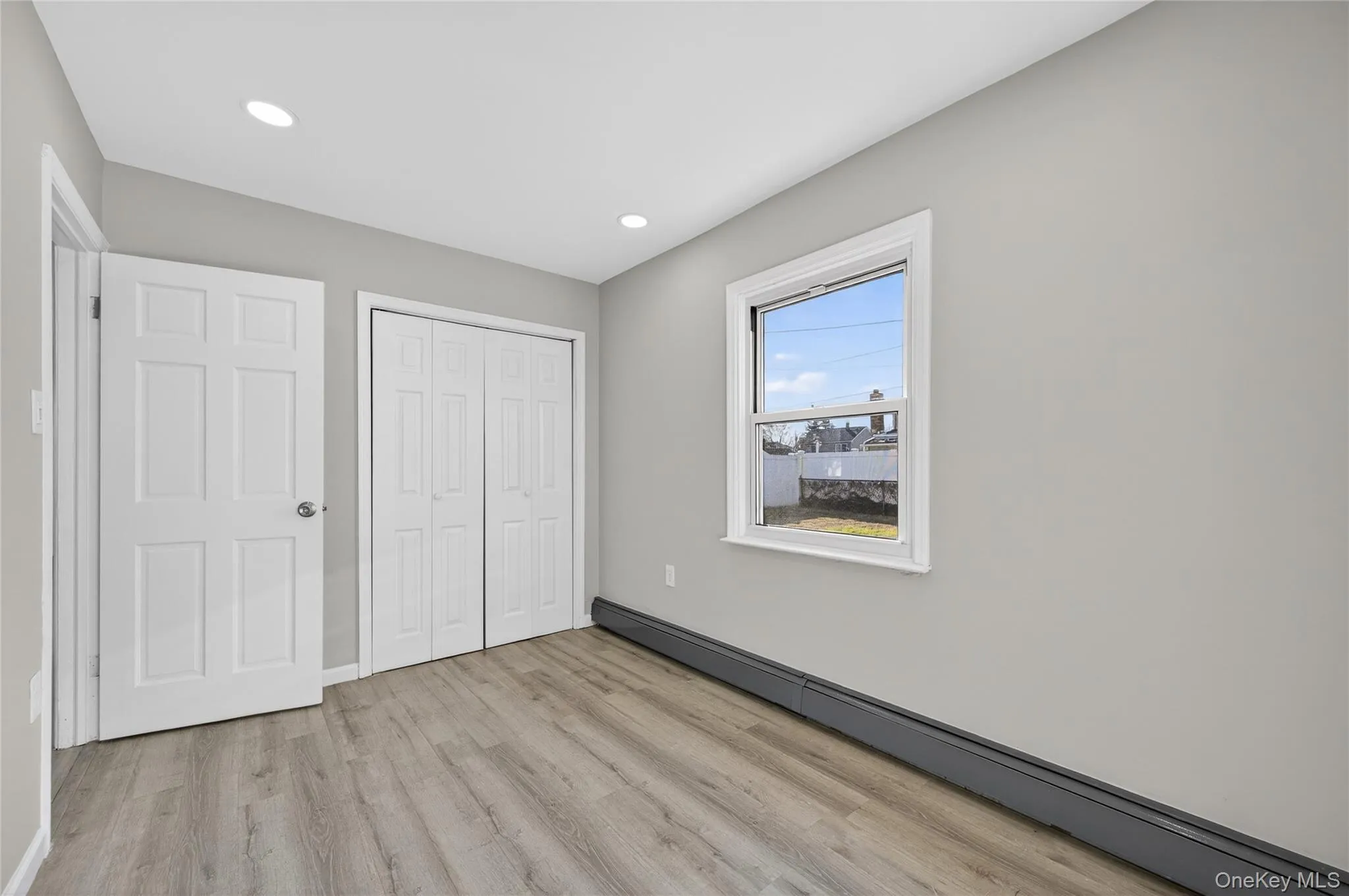 Unfurnished bedroom featuring a baseboard heating unit, light wood-type flooring, a closet, and recessed lighting Unfurnished bedroom featuring a baseboard heating unit, light wood-type flooring, a closet, and recessed lighting