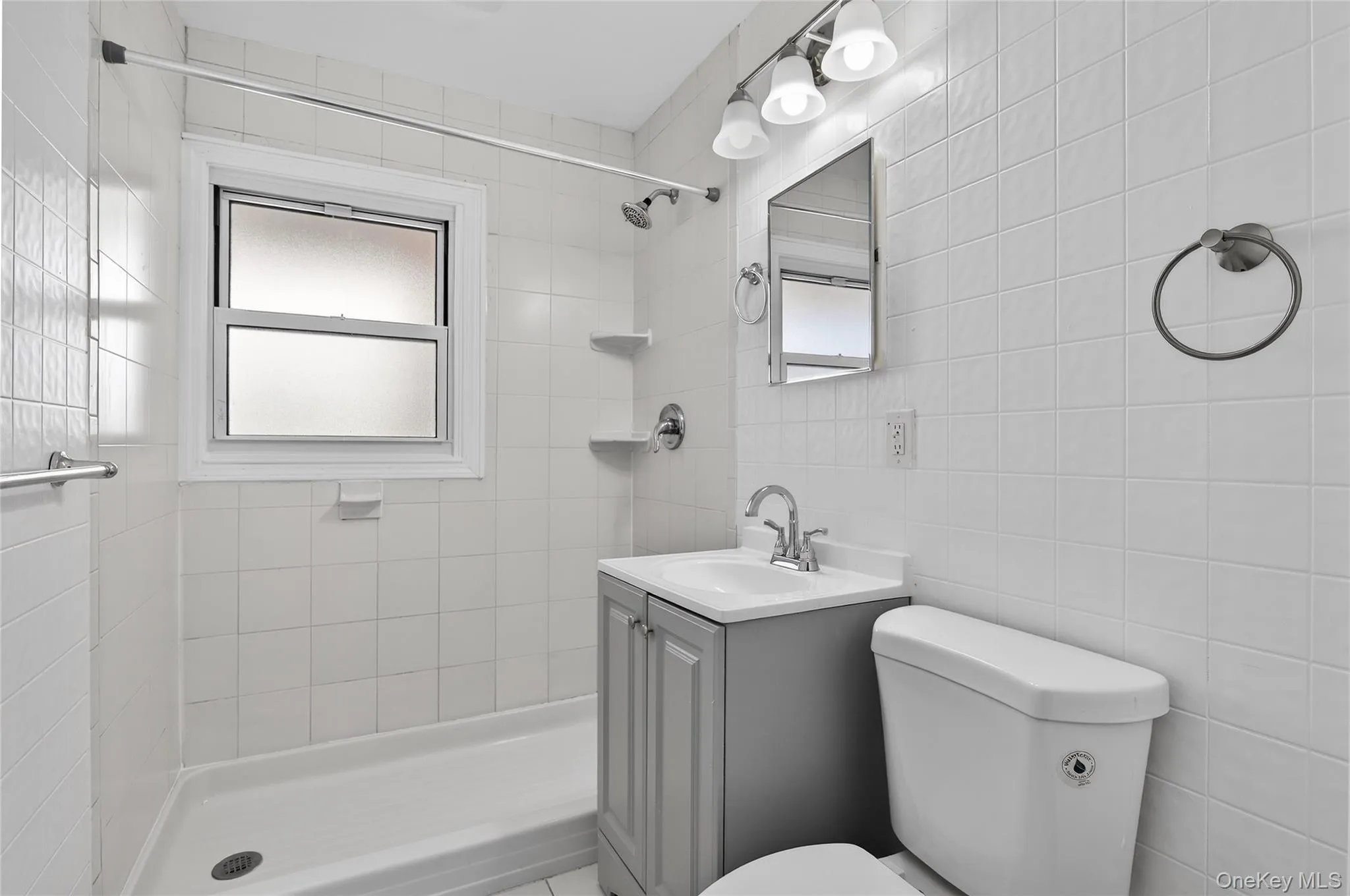 Bathroom featuring a shower stall and vanity Bathroom featuring a shower stall and vanity
