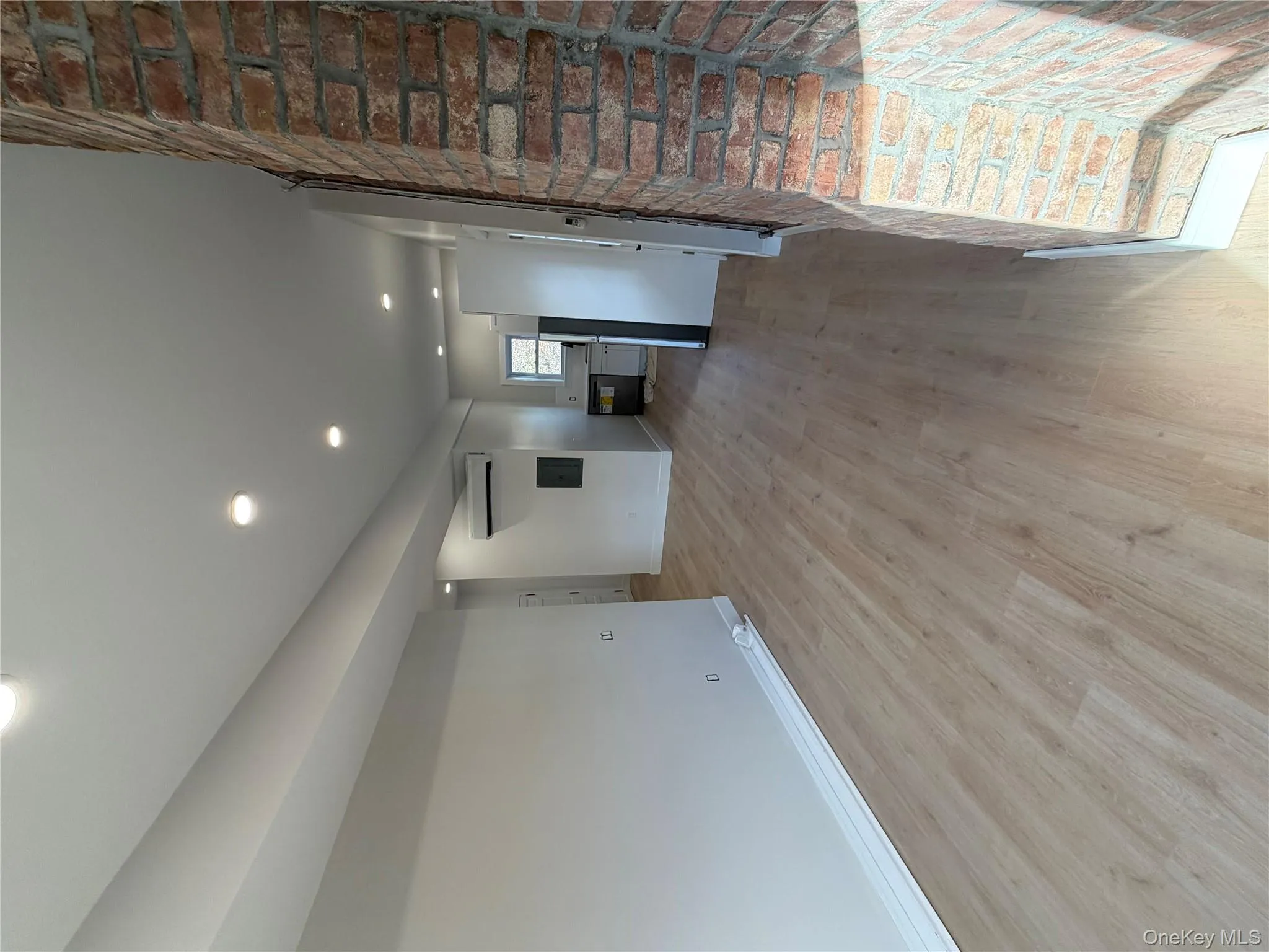 Unfurnished living room with recessed lighting, light wood-style floors, and a wall mounted air conditioner Unfurnished living room with recessed lighting, light wood-style floors, and a wall mounted air conditioner