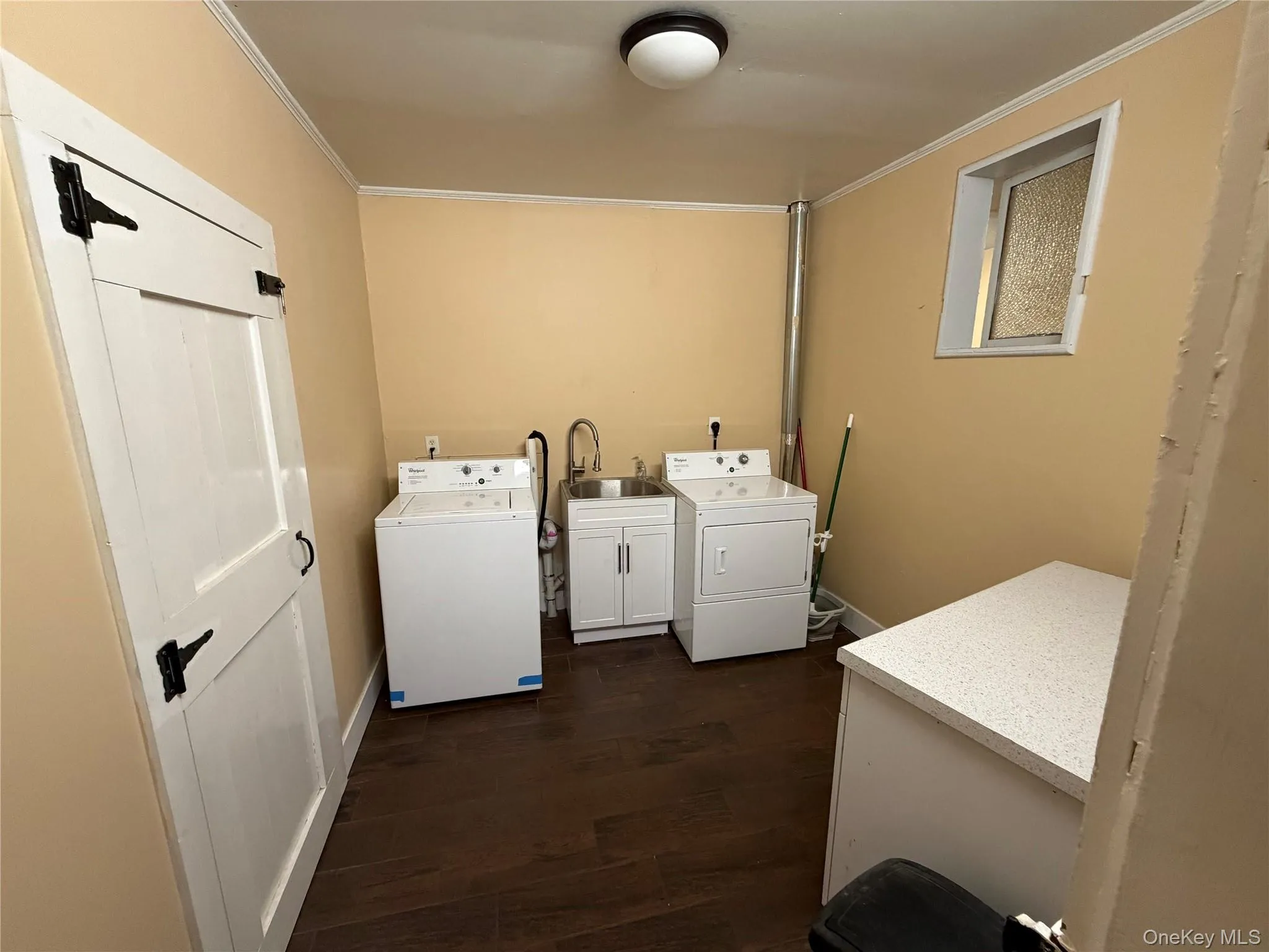 Laundry room featuring washer and dryer, dark wood finished floors, and crown molding Laundry room featuring washer and dryer, dark wood finished floors, and crown molding