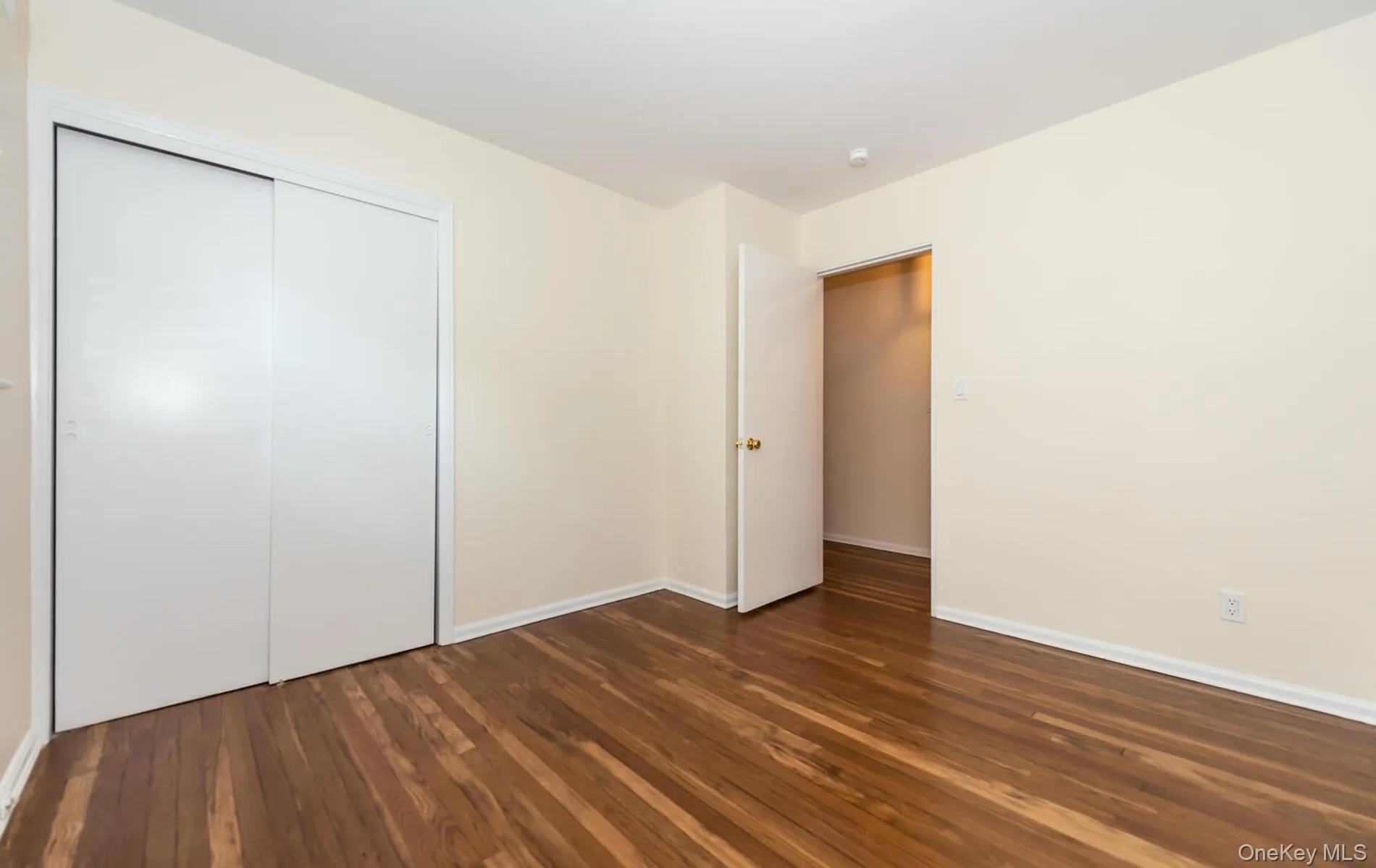 Unfurnished bedroom with dark wood-style flooring and a closet Unfurnished bedroom with dark wood-style flooring and a closet