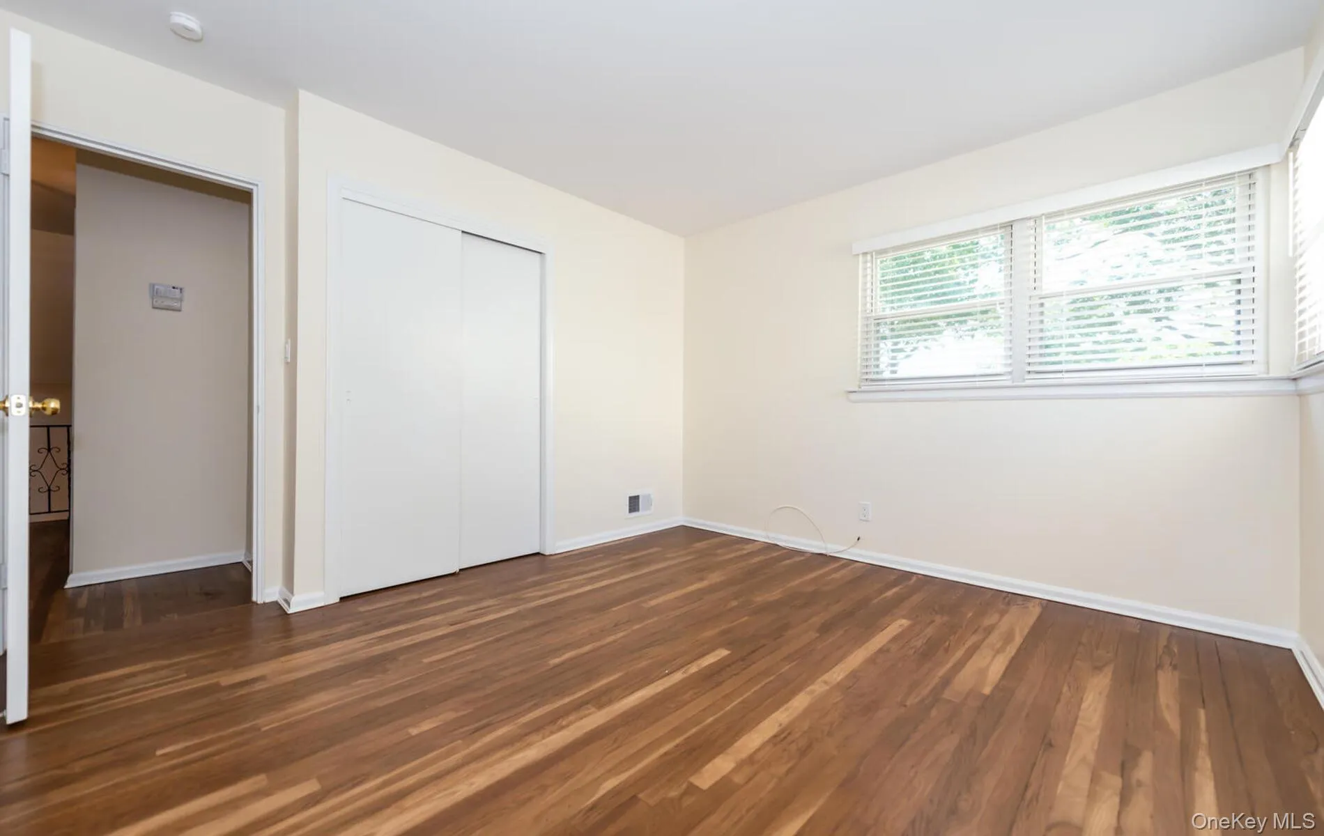 Unfurnished bedroom with dark wood-style flooring and a closet Unfurnished bedroom with dark wood-style flooring and a closet