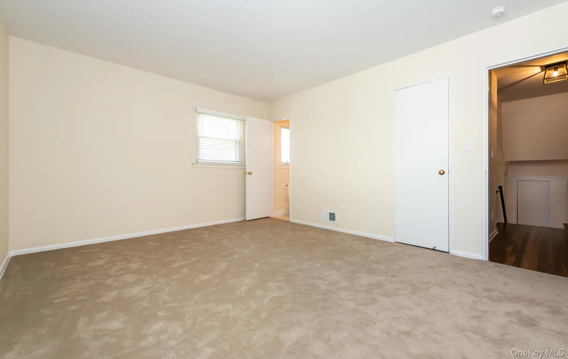 Unfurnished bedroom with carpet flooring and baseboards Unfurnished bedroom with carpet flooring and baseboards