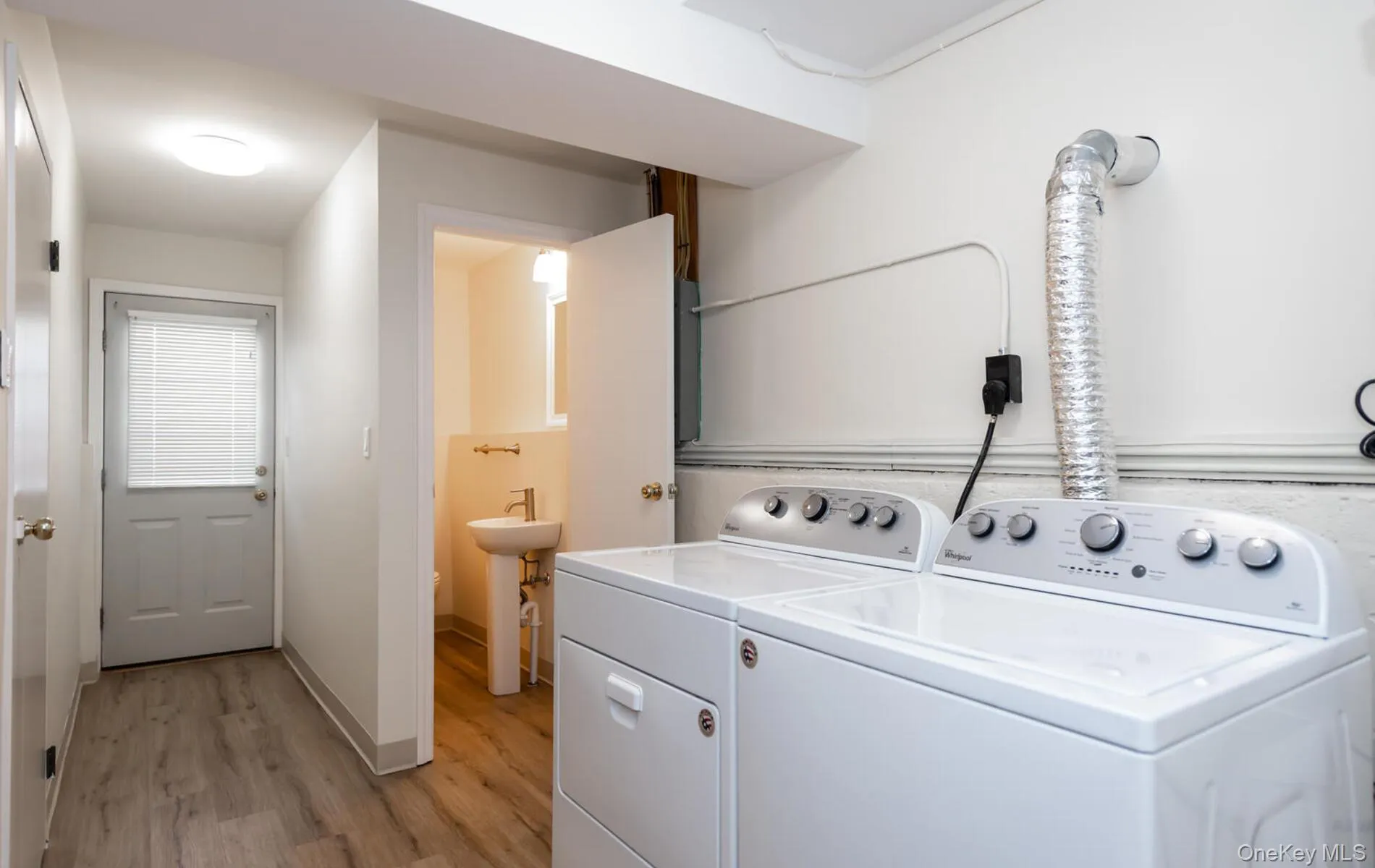 Laundry room featuring light wood finished floors and washer and clothes dryer Laundry room featuring light wood finished floors and washer and clothes dryer