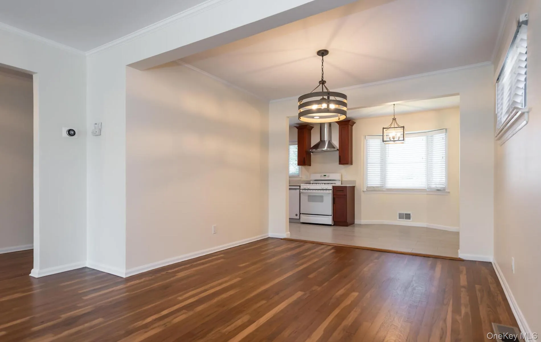 Unfurnished dining area with dark wood finished floors and ornamental molding Unfurnished dining area with dark wood finished floors and ornamental molding