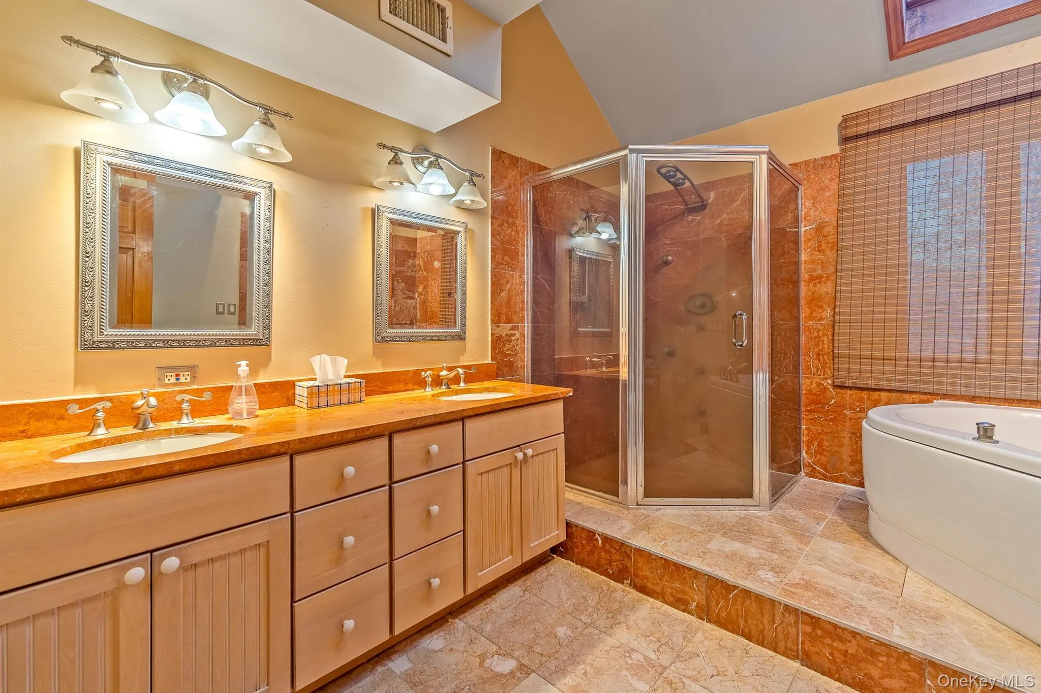 Bathroom featuring a stall shower, double vanity, vaulted ceiling, and a bath Bathroom featuring a stall shower, double vanity, vaulted ceiling, and a bath