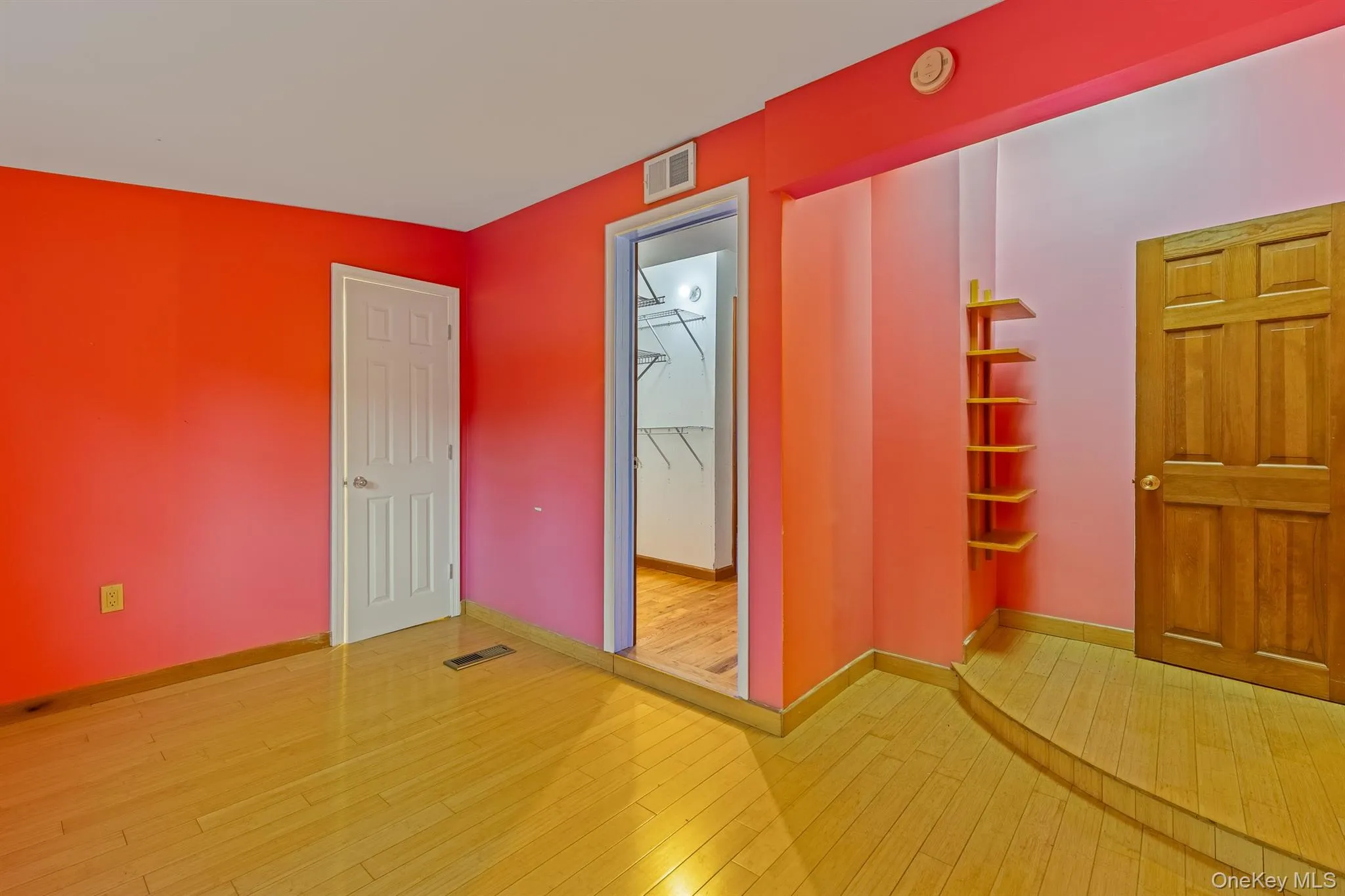 Unfurnished bedroom featuring light wood finished floors and a spacious closet Unfurnished bedroom featuring light wood finished floors and a spacious closet