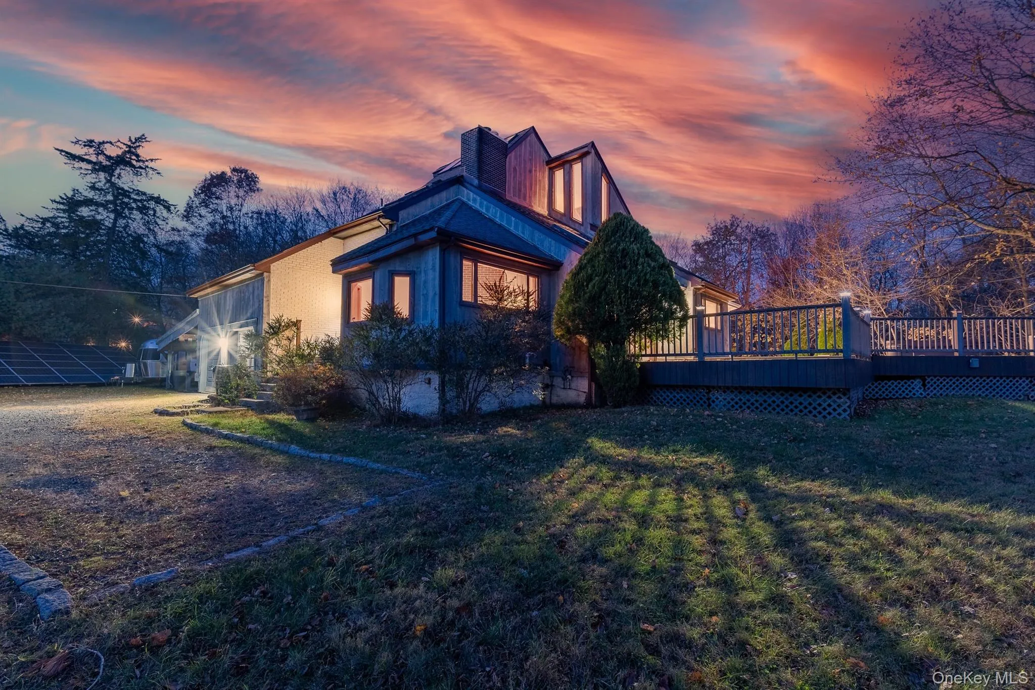View of side of property with a chimney, a wooden deck, and a lawn View of side of property with a chimney, a wooden deck, and a lawn
