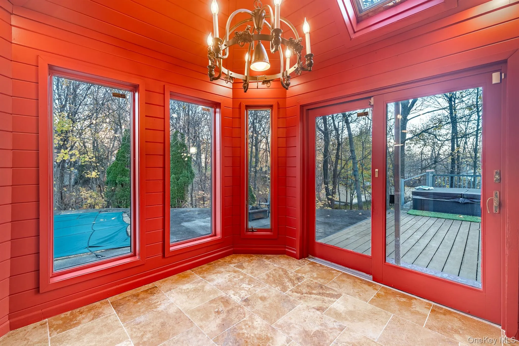 Unfurnished sunroom with plenty of natural light, a chandelier, wooden walls, and a skylight Unfurnished sunroom with plenty of natural light, a chandelier, wooden walls, and a skylight