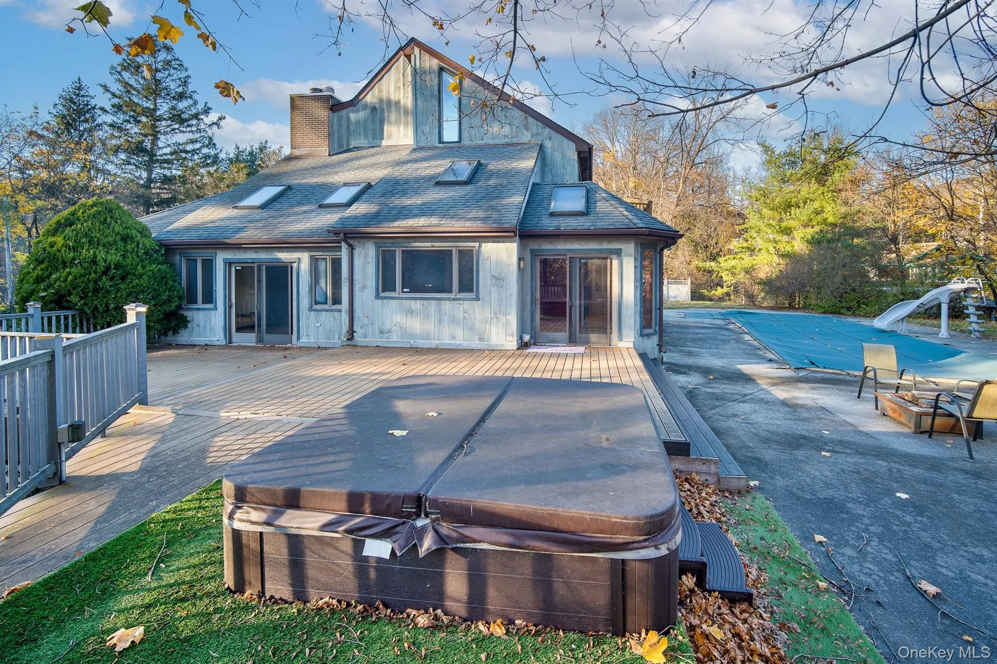 Back of house featuring a deck and a hot tub Back of house featuring a deck and a hot tub