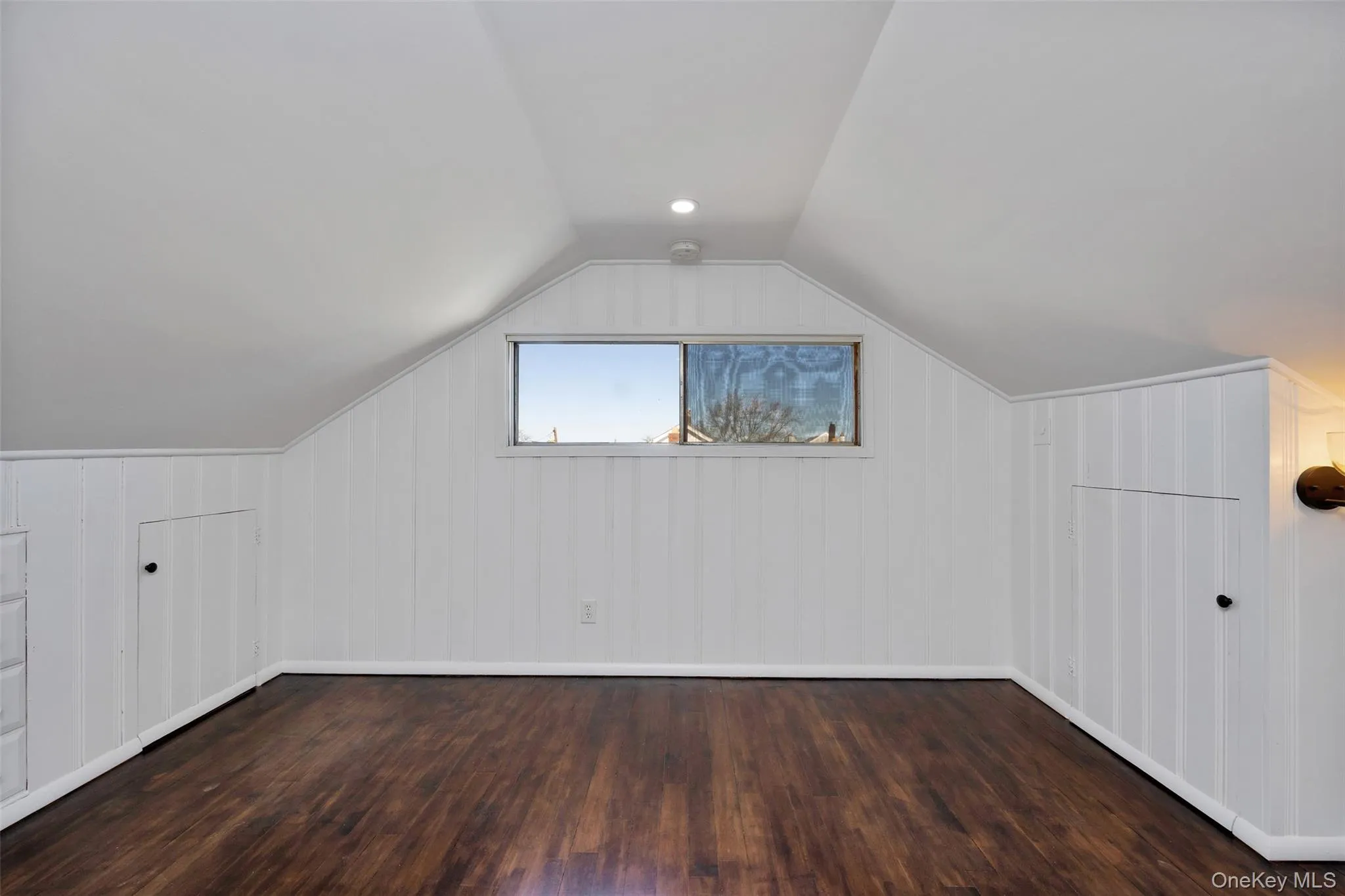 Bonus room with lofted ceiling and dark wood-style flooring Bonus room with lofted ceiling and dark wood-style flooring