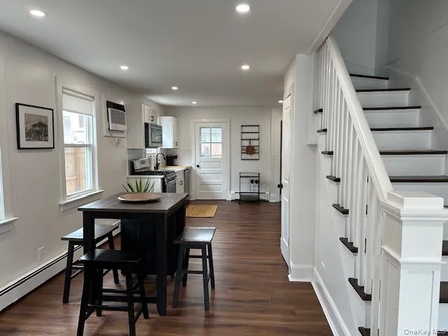 Dining space featuring stairway, dark wood-style floors, a baseboard radiator, a baseboard heating unit, and recessed lighting Dining space featuring stairway, dark wood-style floors, a baseboard radiator, a baseboard heating unit, and recessed lighting