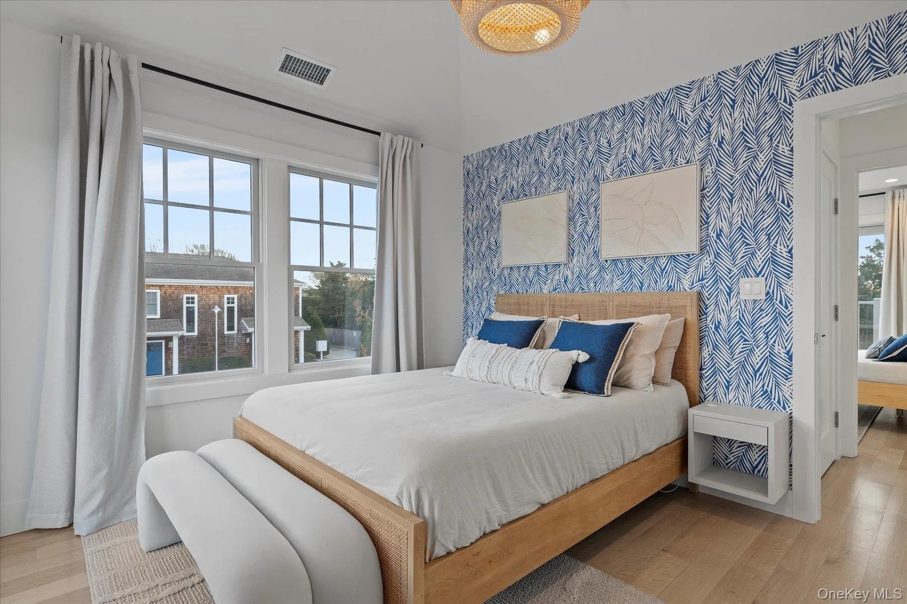 Bedroom featuring wood finished floors and wallpapered walls Bedroom featuring wood finished floors and wallpapered walls