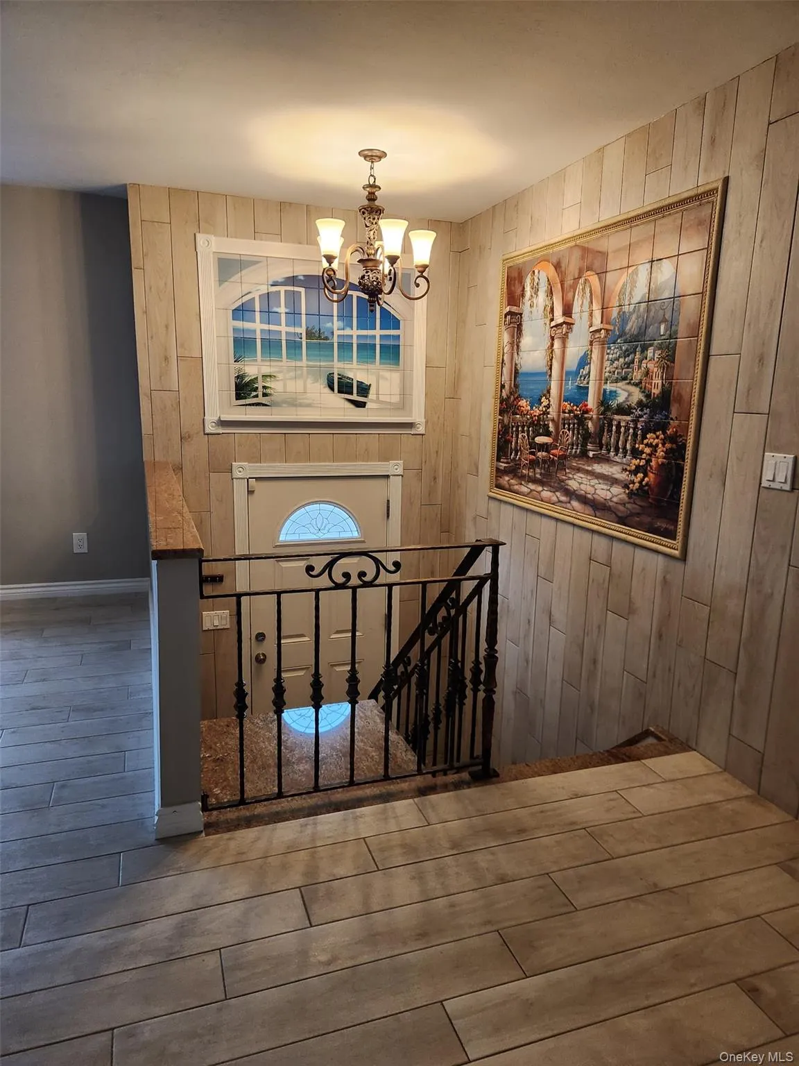 Entryway featuring wood walls, wood finish floors, and a chandelier Entryway featuring wood walls, wood finish floors, and a chandelier