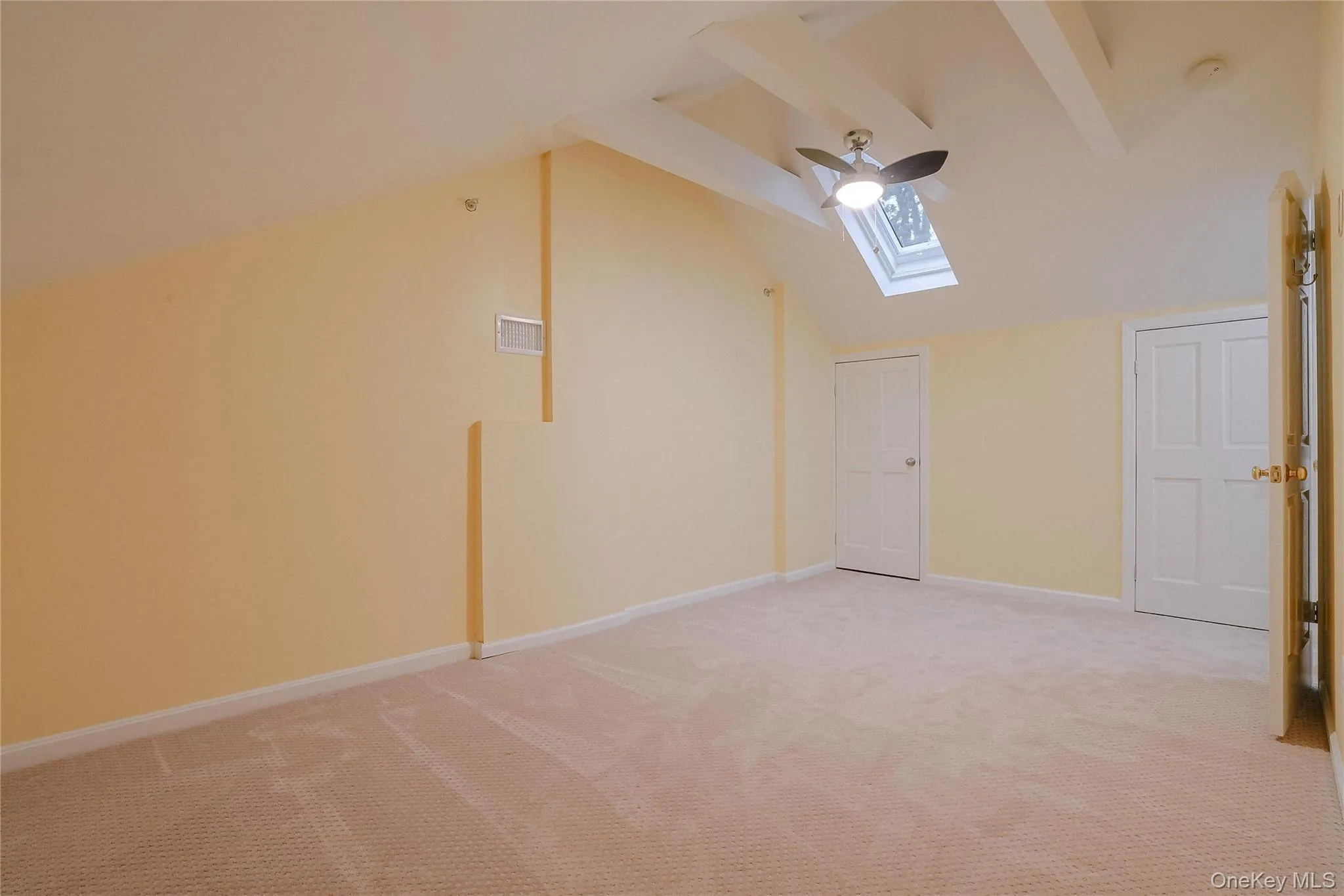 Finished walk up Attic space. Additional living space with a skylight, light colored carpet, ceiling fan, and lofted ceiling Finished walk up Attic space. Additional living space with a skylight, light colored carpet, ceiling fan, and lofted ceiling