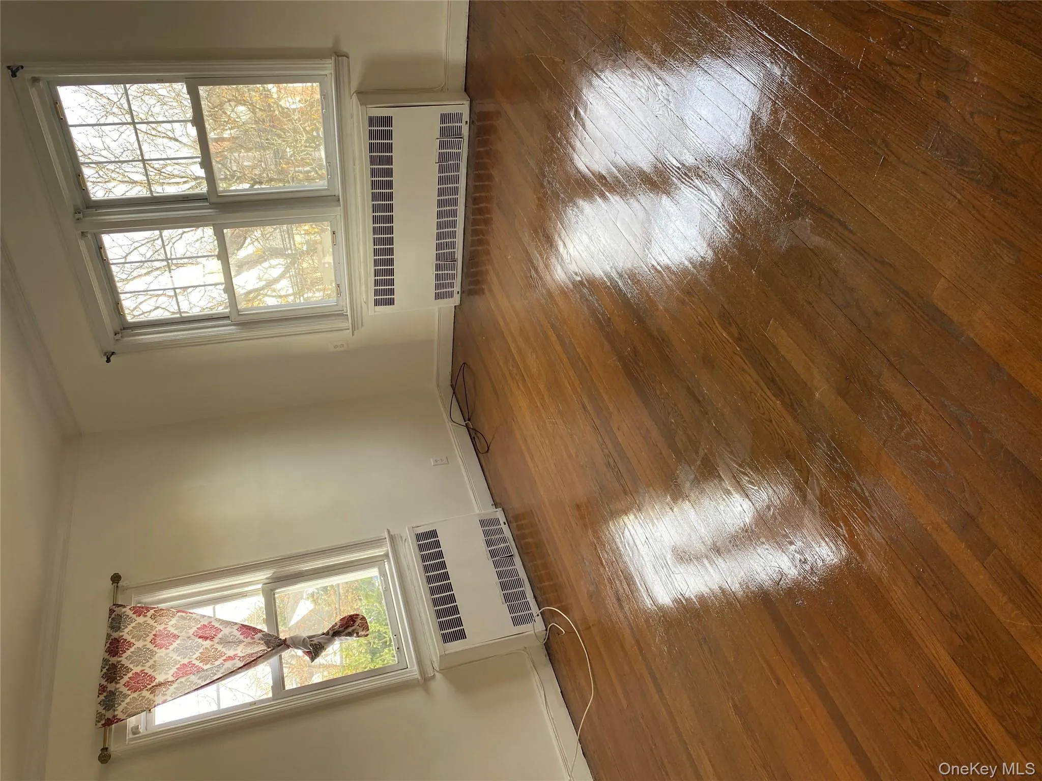 Spare room featuring radiator heating unit, dark wood finished floors, and ornamental molding Spare room featuring radiator heating unit, dark wood finished floors, and ornamental molding