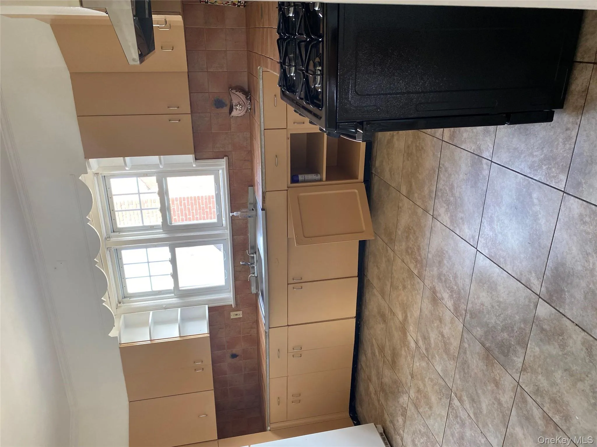 Kitchen with open shelves, stove, backsplash, light countertops, and ornamental molding Kitchen with open shelves, stove, backsplash, light countertops, and ornamental molding