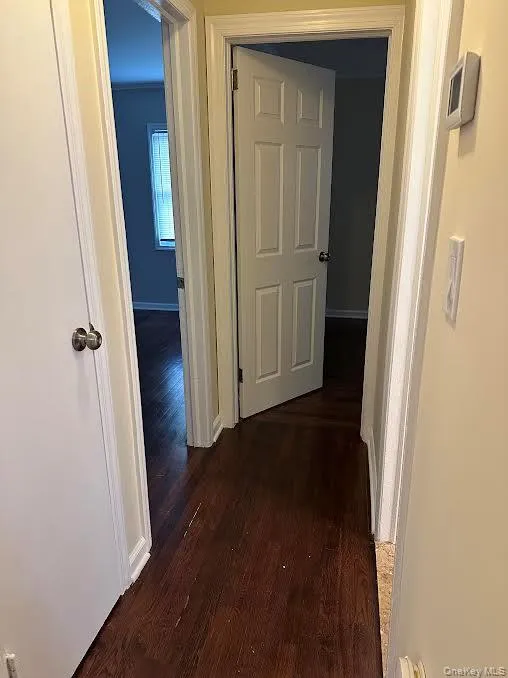 Hall featuring dark wood finished floors and baseboards Hall featuring dark wood finished floors and baseboards