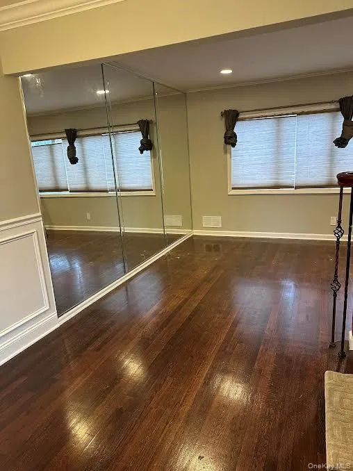 Unfurnished bedroom with crown molding, dark wood-style flooring, a closet, and recessed lighting Unfurnished bedroom with crown molding, dark wood-style flooring, a closet, and recessed lighting