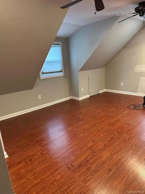 Bonus room featuring ceiling fan, lofted ceiling, and dark wood-style floors Bonus room featuring ceiling fan, lofted ceiling, and dark wood-style floors
