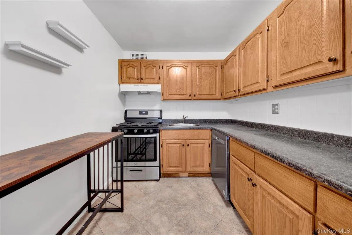 Kitchen featuring stainless steel appliances, under cabinet range hood, and tasteful backsplash Kitchen featuring stainless steel appliances, under cabinet range hood, and tasteful backsplash