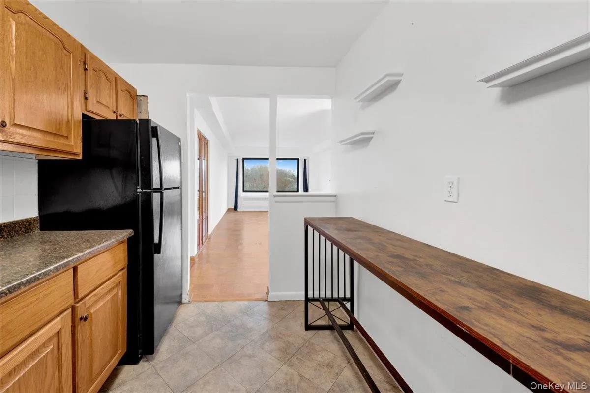 Kitchen featuring freestanding refrigerator, cabinets, and open shelves Kitchen featuring freestanding refrigerator, cabinets, and open shelves