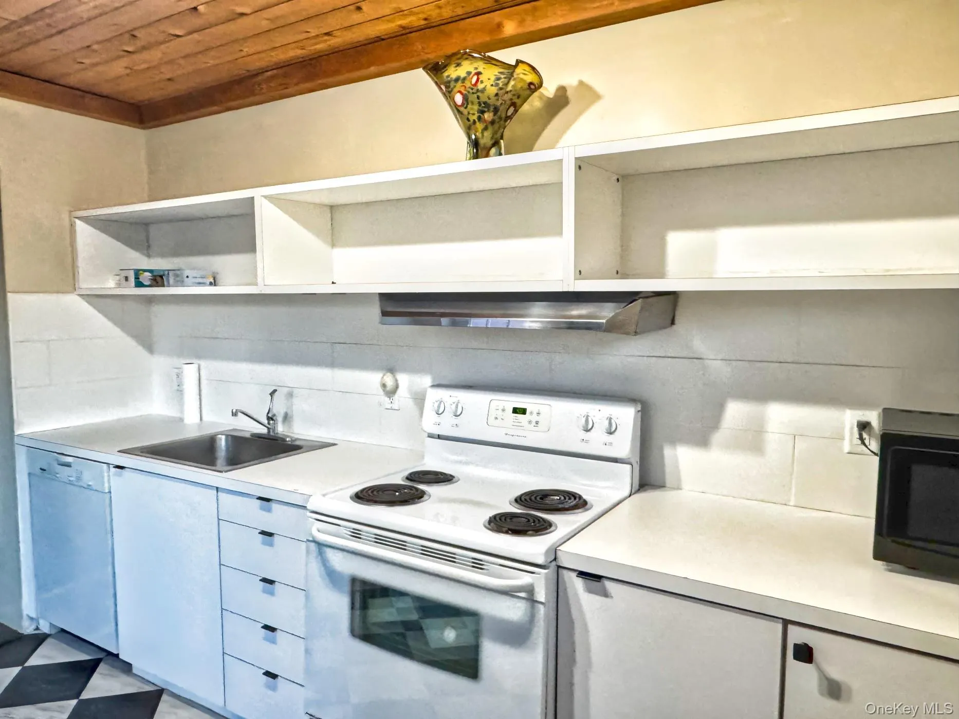 Kitchen featuring white appliances, wood ceiling, light flooring, light countertops, and under cabinet range hood Kitchen featuring white appliances, wood ceiling, light flooring, light countertops, and under cabinet range hood