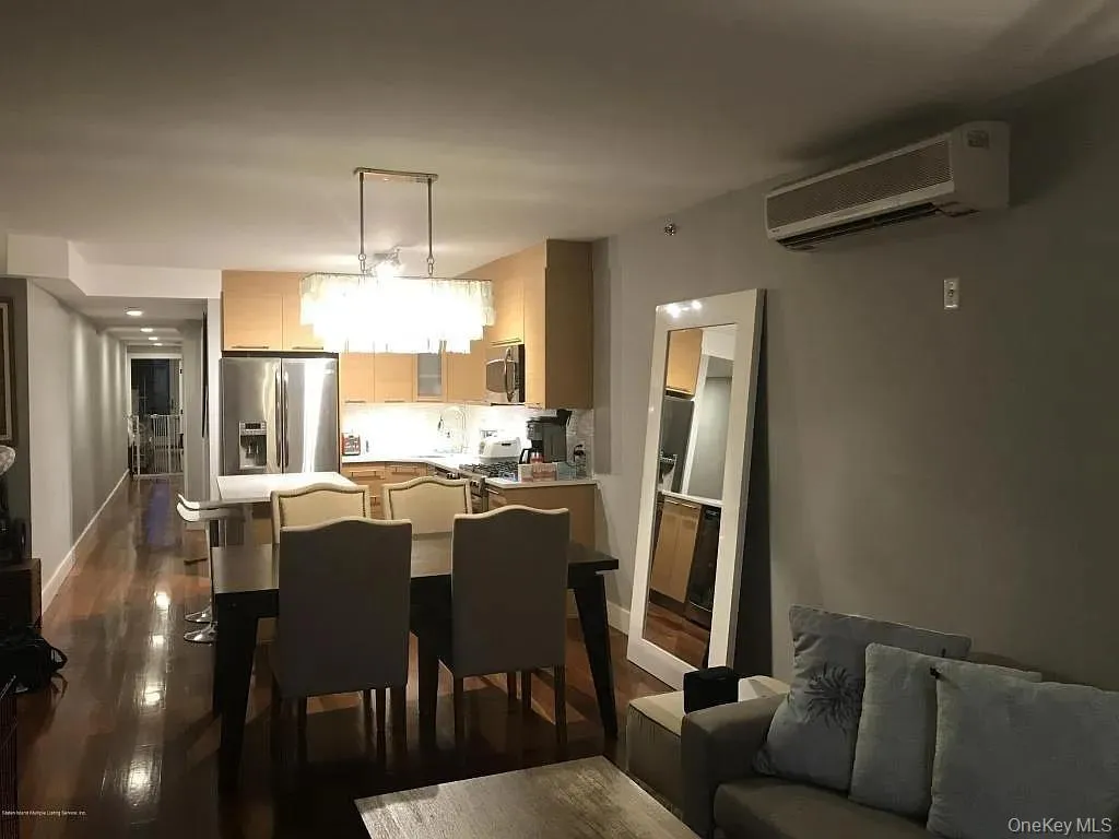 Dining area featuring a wall mounted AC and dark wood-type flooring Dining area featuring a wall mounted AC and dark wood-type flooring