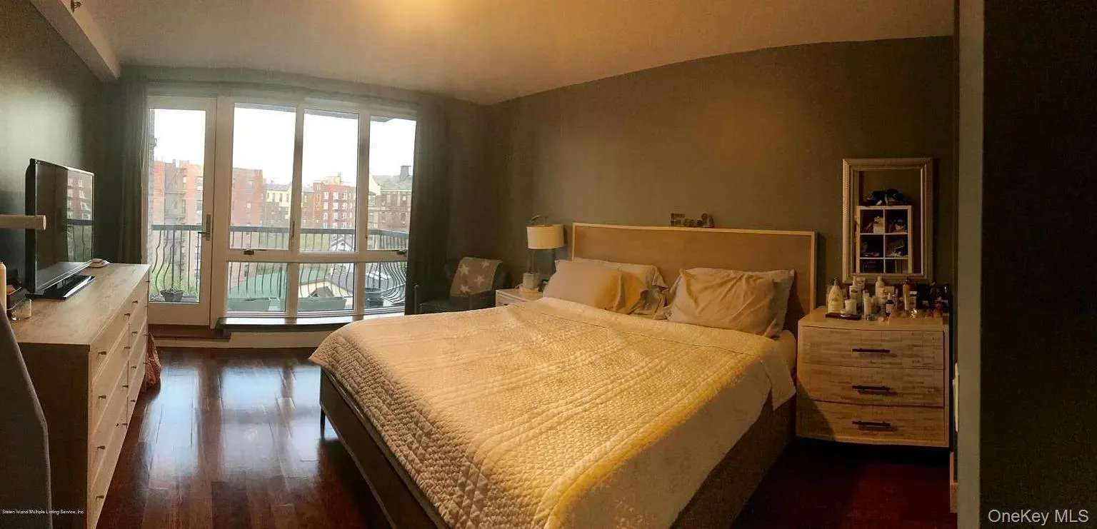 Bedroom with dark wood-style flooring and a city view Bedroom with dark wood-style flooring and a city view