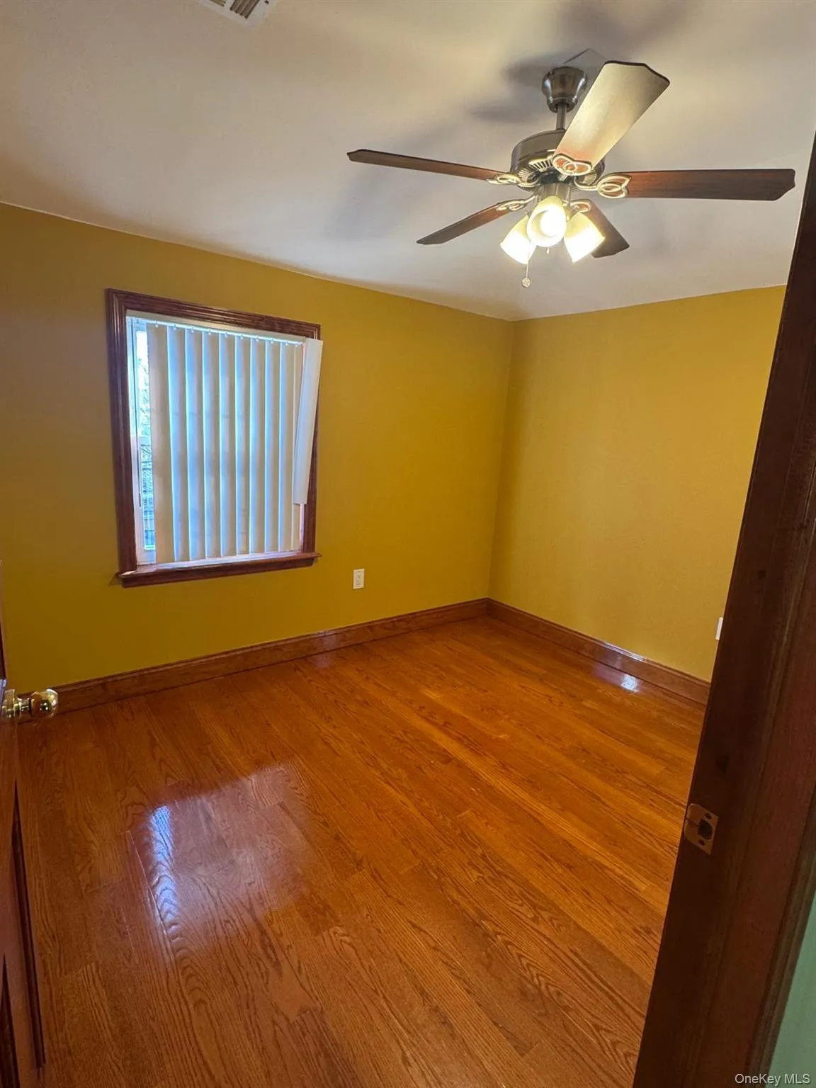 Spare room featuring wood finished floors and a ceiling fan Spare room featuring wood finished floors and a ceiling fan