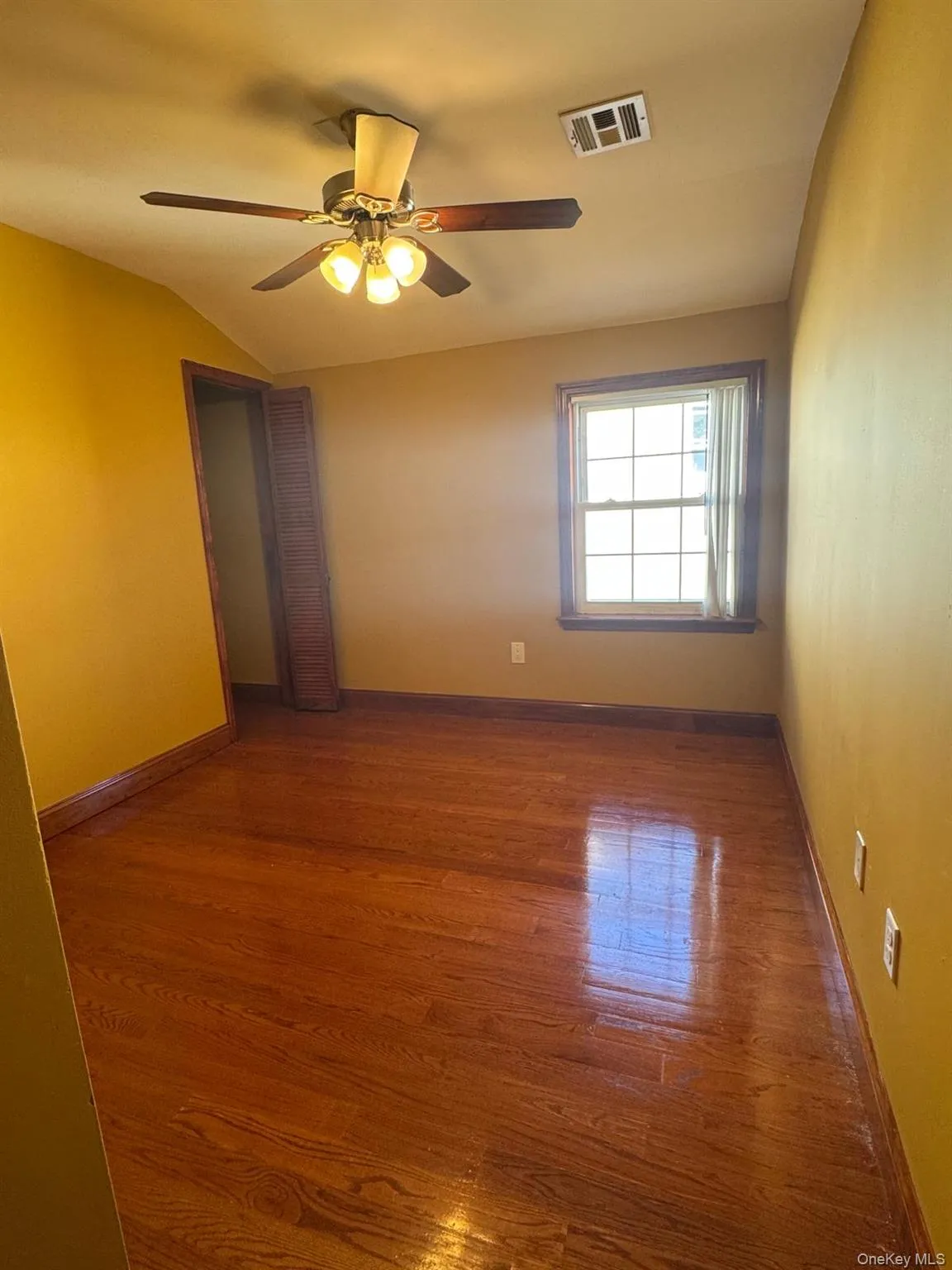 Spare room with wood finished floors and ceiling fan Spare room with wood finished floors and ceiling fan