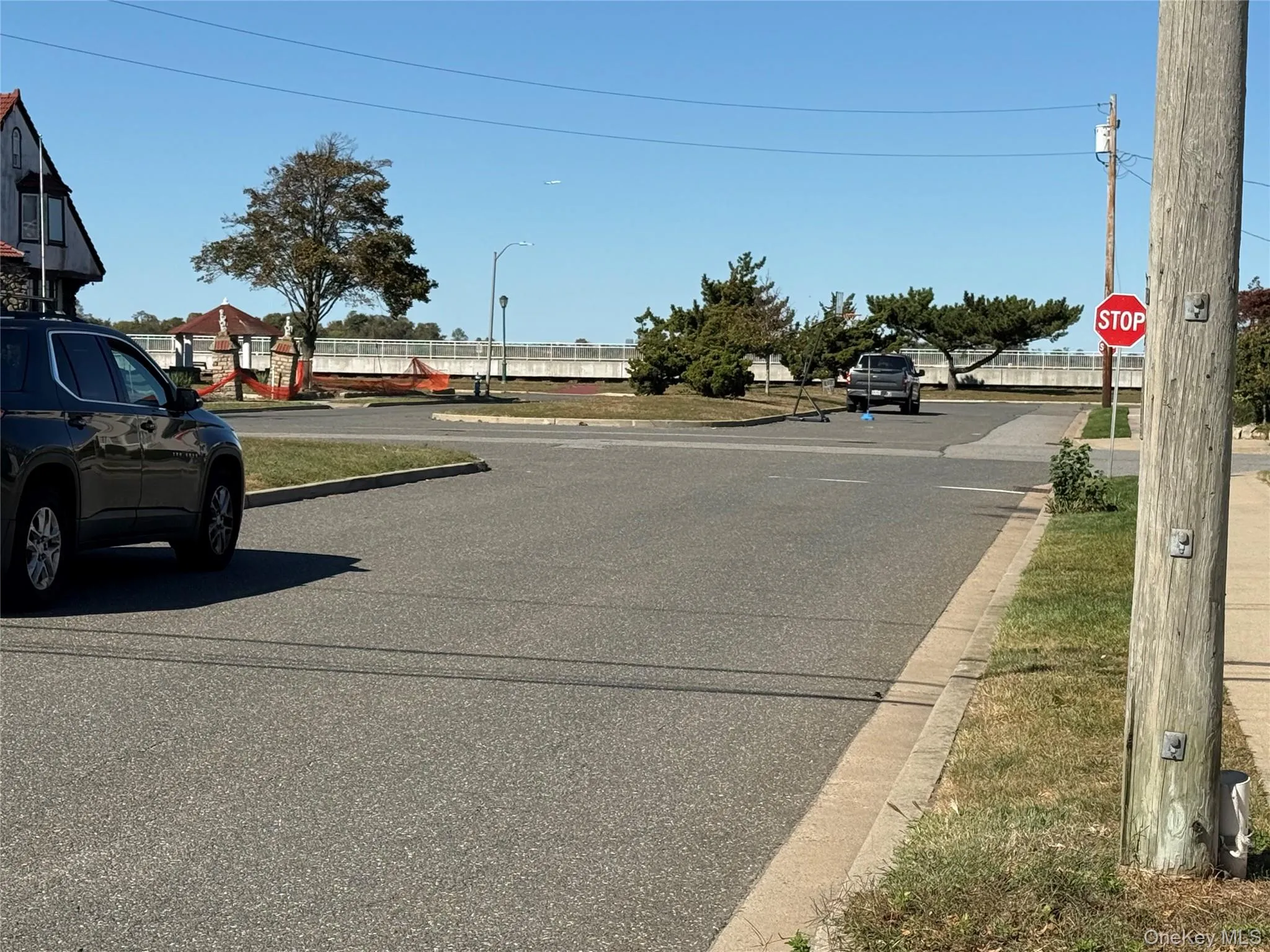 View of asphalt road featuring traffic signs and curbs View of asphalt road featuring traffic signs and curbs