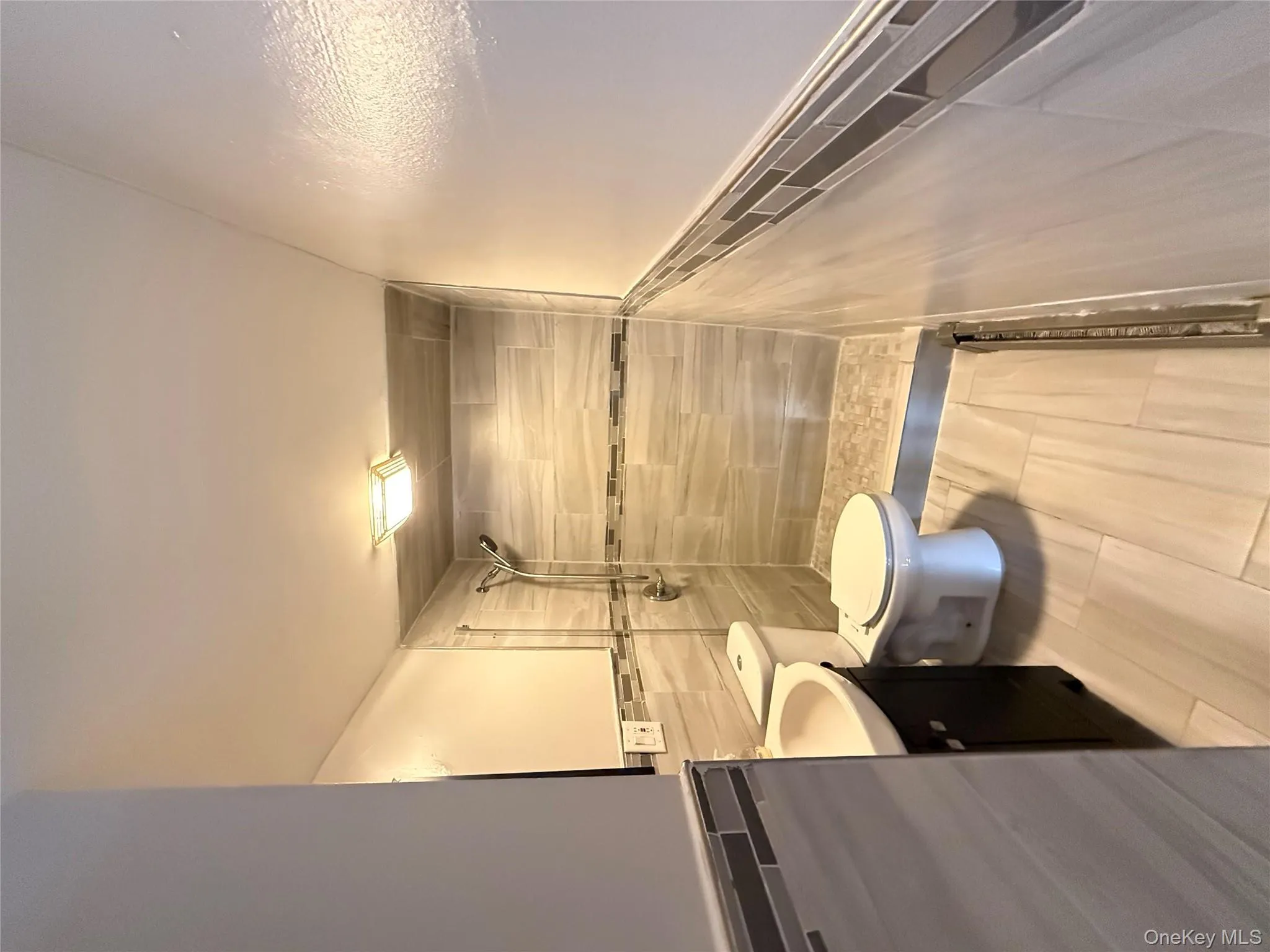 Bathroom with tile walls, vanity, a shower stall, and wainscoting Bathroom with tile walls, vanity, a shower stall, and wainscoting