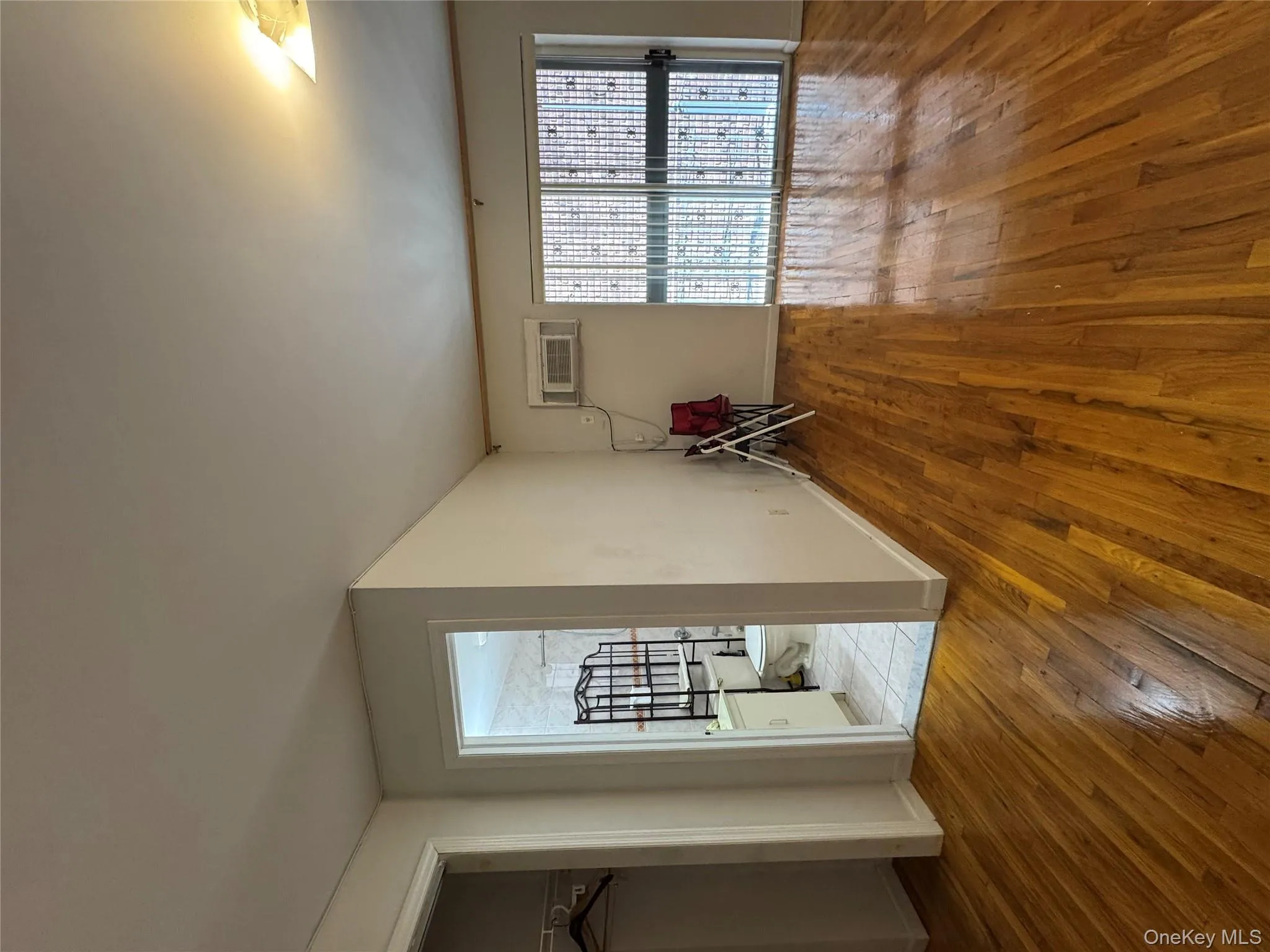 Unfurnished living room featuring light wood finished floors and a wall mounted AC Unfurnished living room featuring light wood finished floors and a wall mounted AC