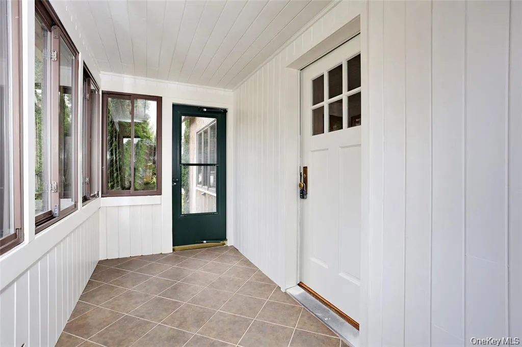 Unfurnished sunroom with tile patterned floors and wood ceiling Unfurnished sunroom with tile patterned floors and wood ceiling