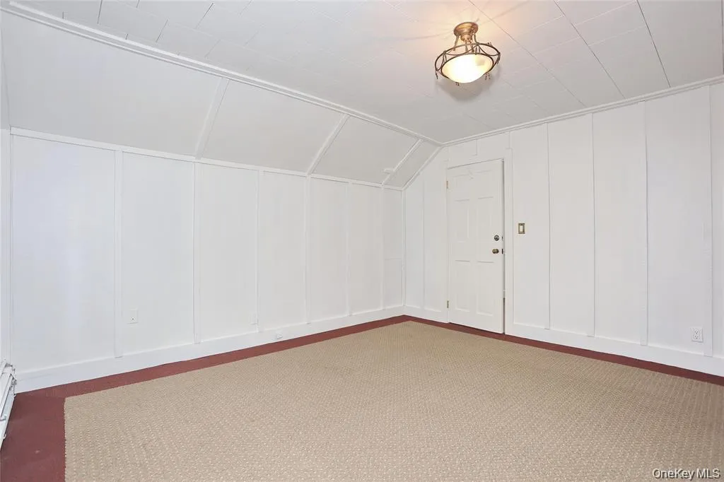 Bonus room with a decorative wall and vaulted ceiling Bonus room with a decorative wall and vaulted ceiling