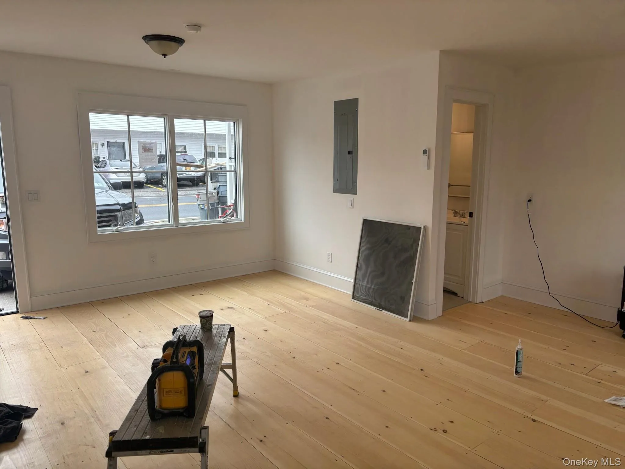 Unfurnished living room with light wood-type flooring and electric panel Unfurnished living room with light wood-type flooring and electric panel