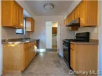 Kitchen featuring black range, dark countertops, under cabinet range hood, and brown cabinets Kitchen featuring black range, dark countertops, under cabinet range hood, and brown cabinets