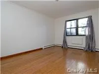 Empty room featuring wood finished floors and baseboards Empty room featuring wood finished floors and baseboards