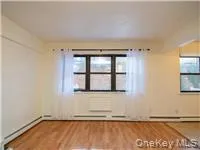 Unfurnished room with plenty of natural light and wood finished floors Unfurnished room with plenty of natural light and wood finished floors